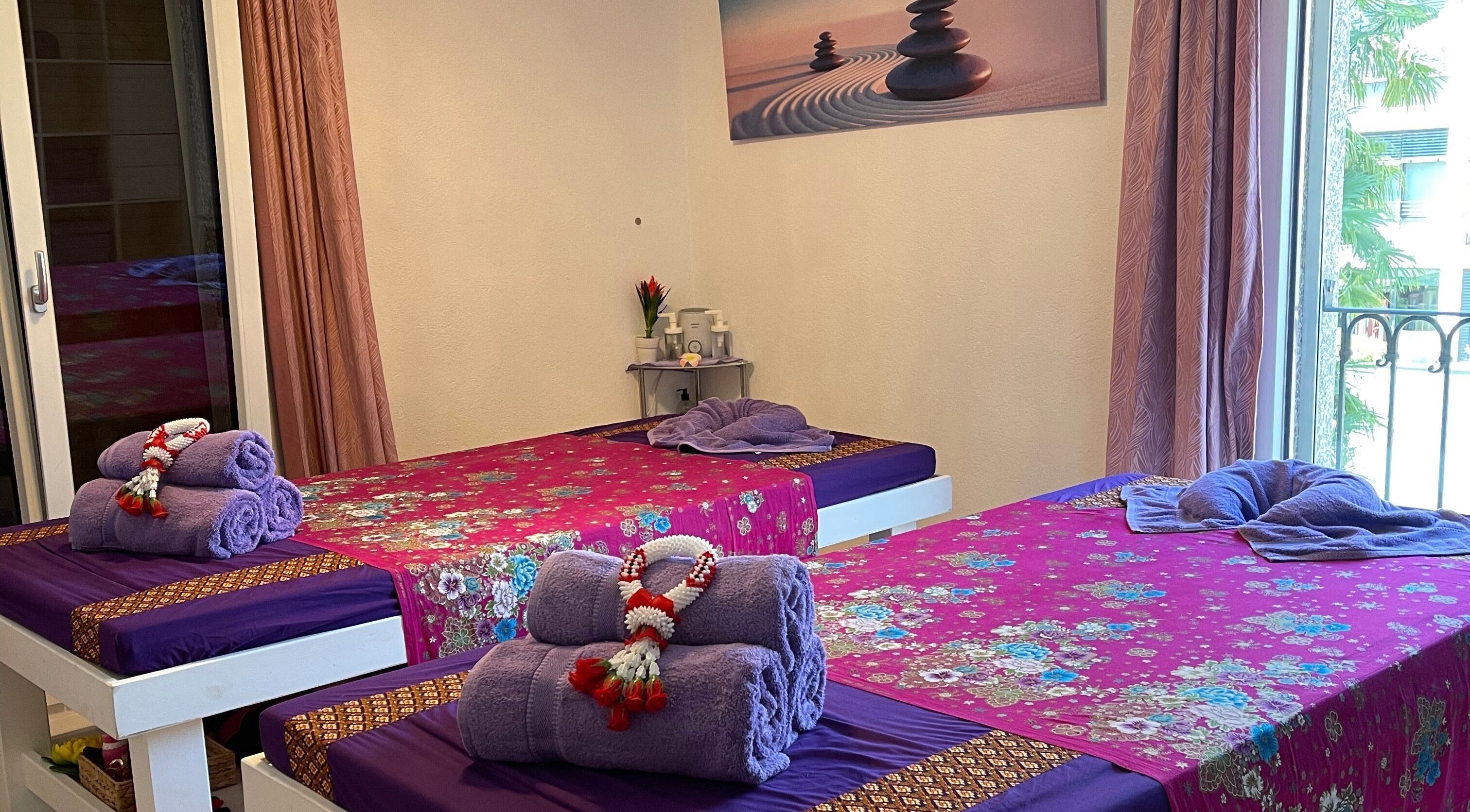 Sala massaggi accogliente all'Ascona Siam Massage Spa, a Ascona, Ticino, CH, con letti decorati.