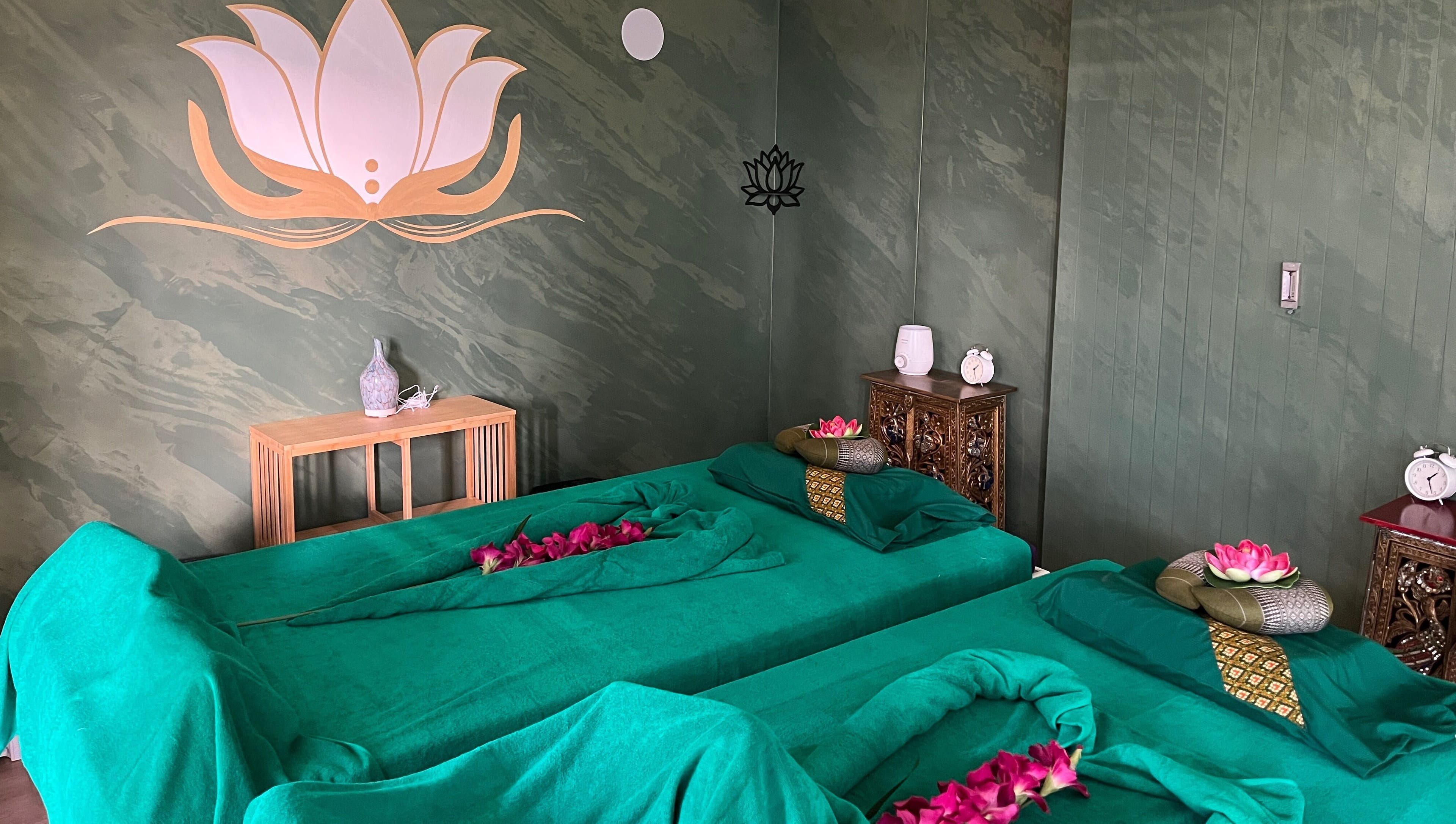 Stanza di massaggio a Locarno Siam Massage, Locarno, Ticino, CH, decorata con fiori e simboli di loto.