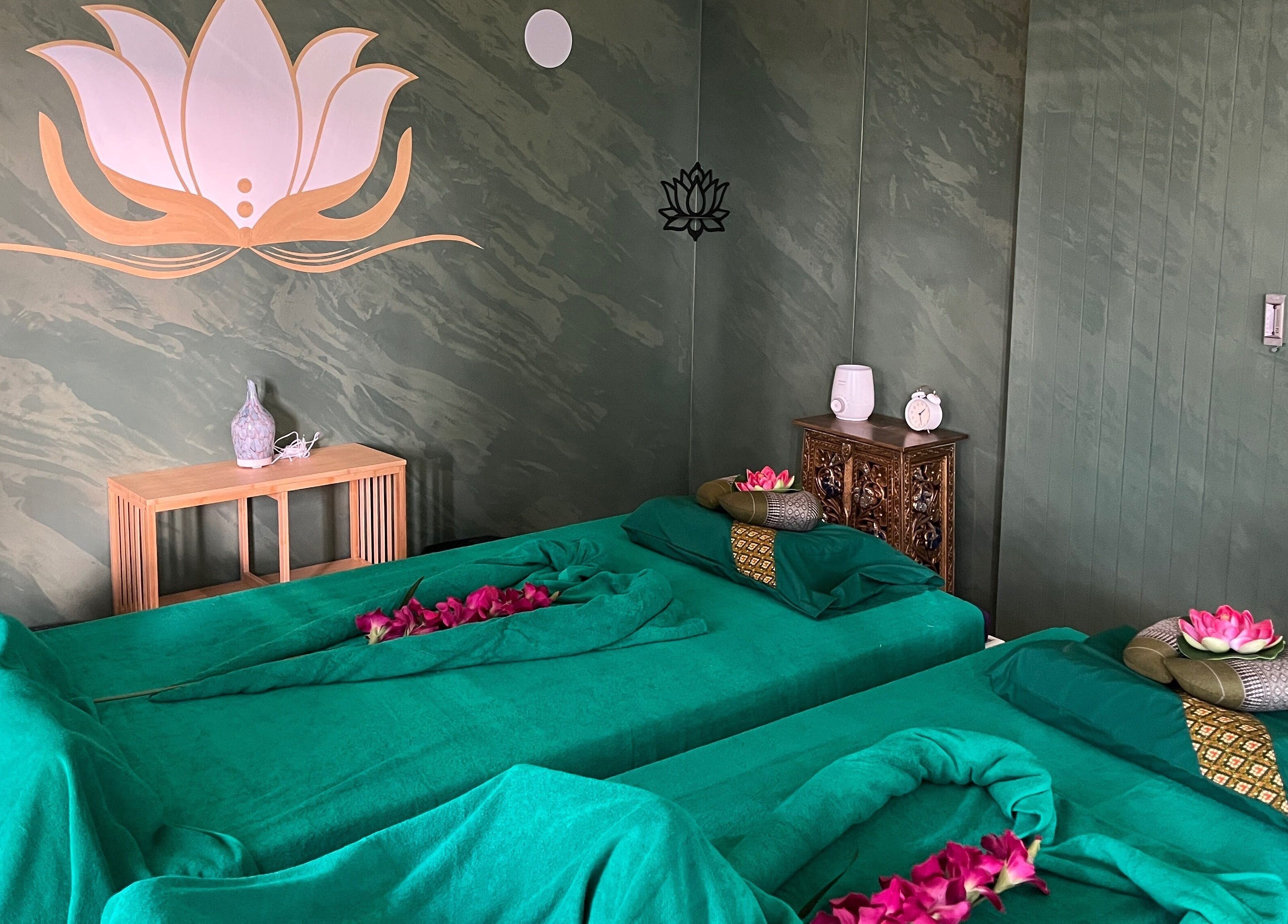 Stanza di massaggio a Locarno Siam Massage, Locarno, Ticino, CH, decorata con fiori e simboli di loto.
