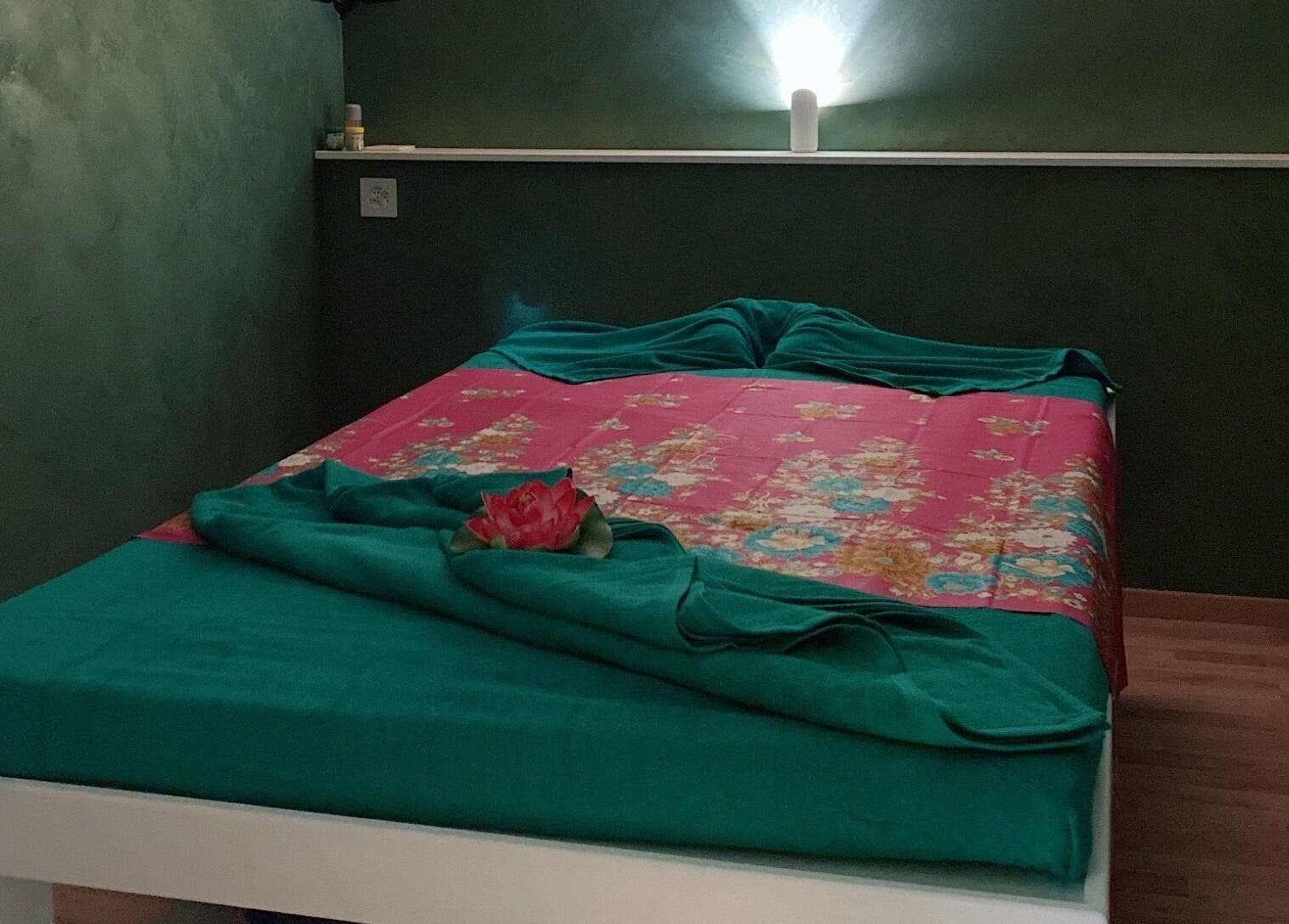 Camera tranquilla a Locarno Siam Massage, Locarno, Ticino, CH con letto verde e rosa.