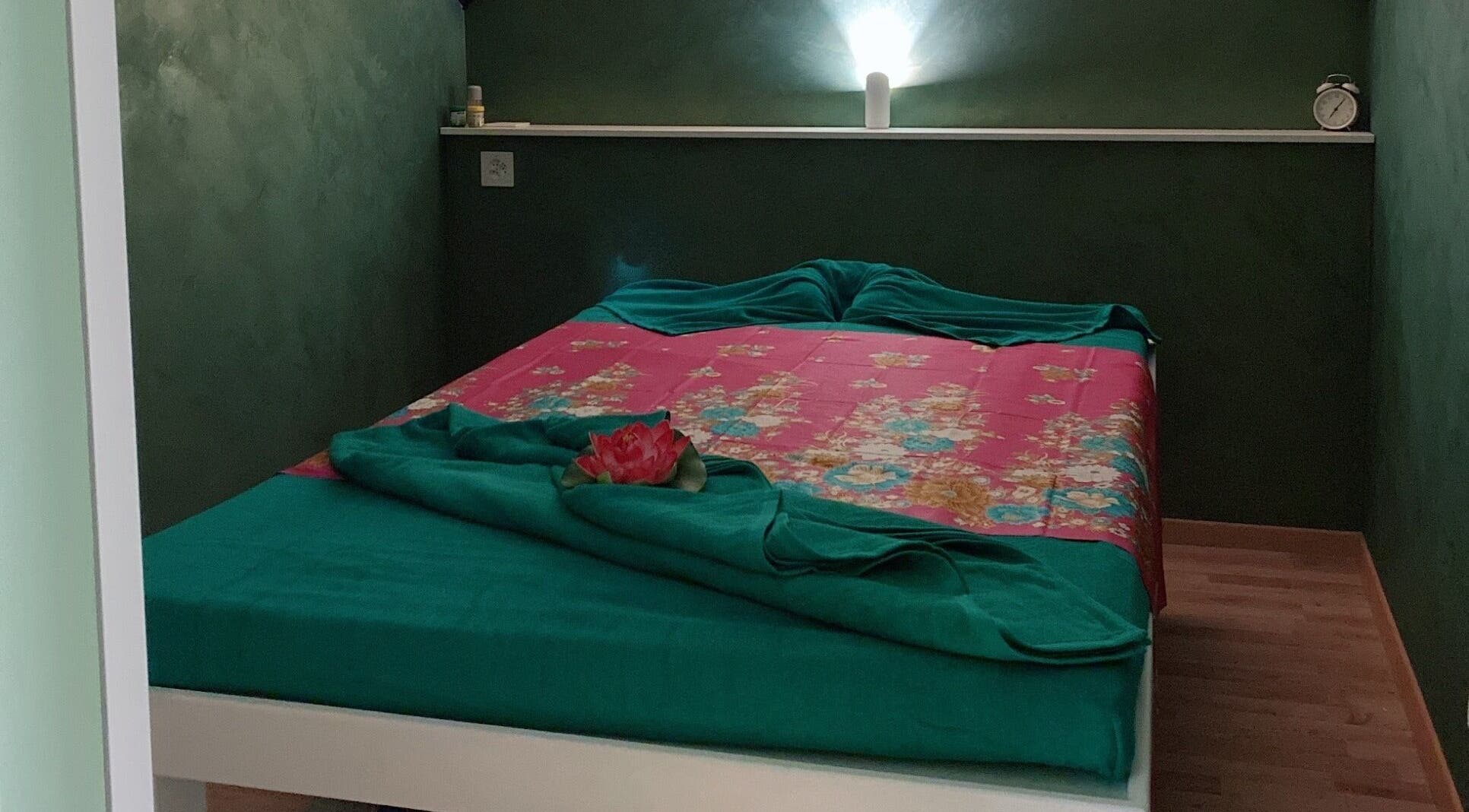 Camera tranquilla a Locarno Siam Massage, Locarno, Ticino, CH con letto verde e rosa.