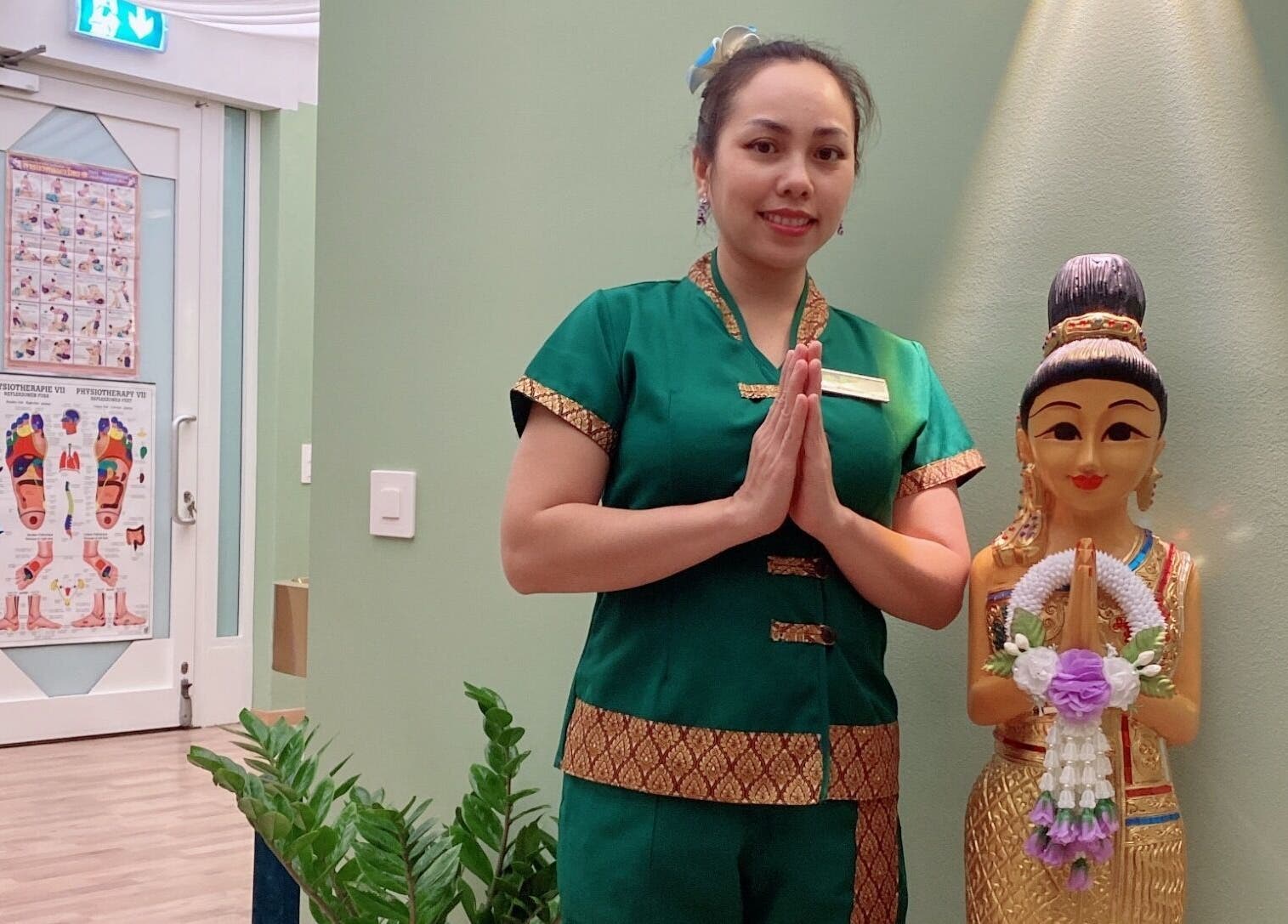 Accoglienza presso Locarno Siam Massage, Locarno, Ticino, CH con hostess in abito tradizionale e statua thailandese.