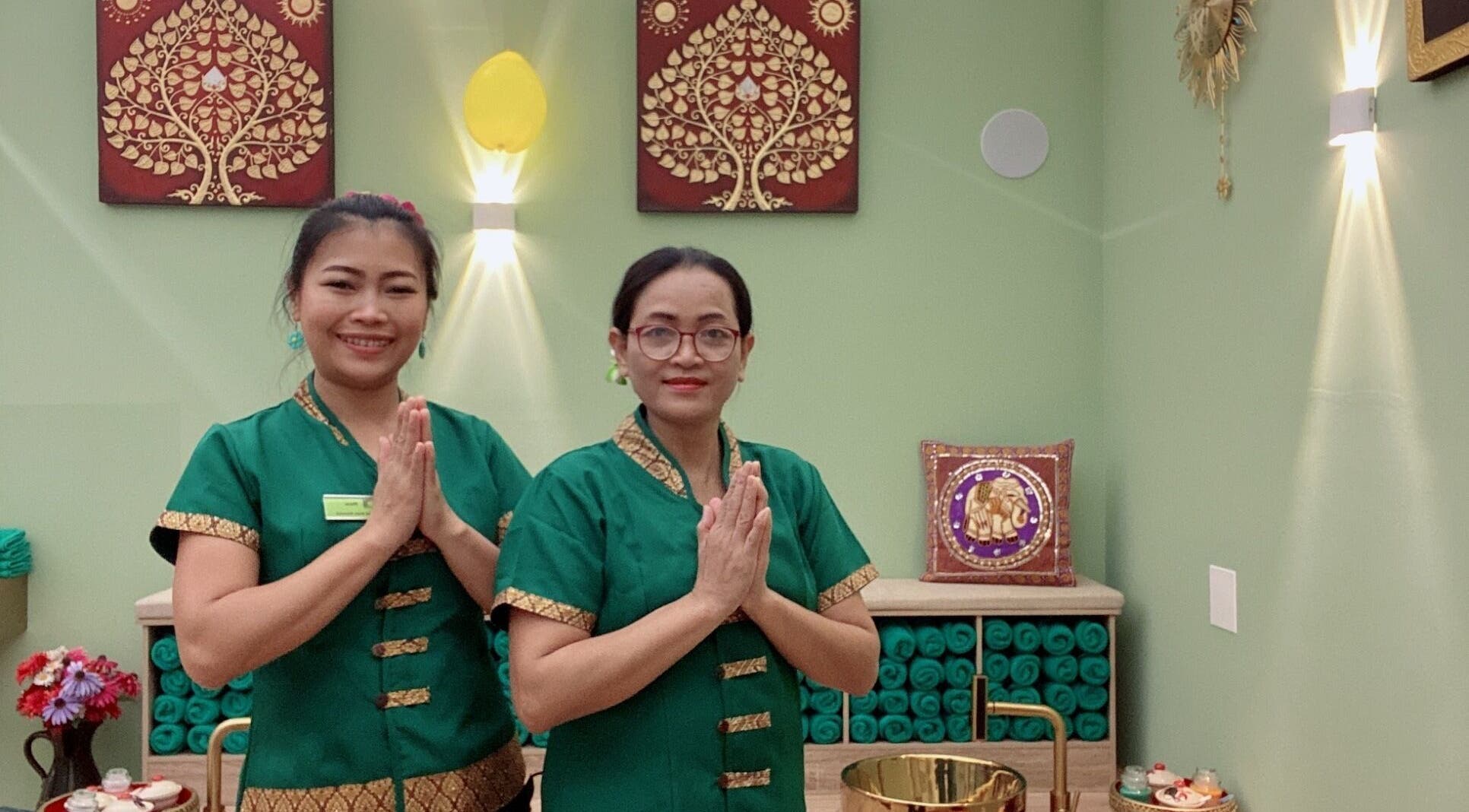 Due terapiste al Locarno Siam Massage, Locarno, Ticino, CH, in abiti tradizionali verdi.