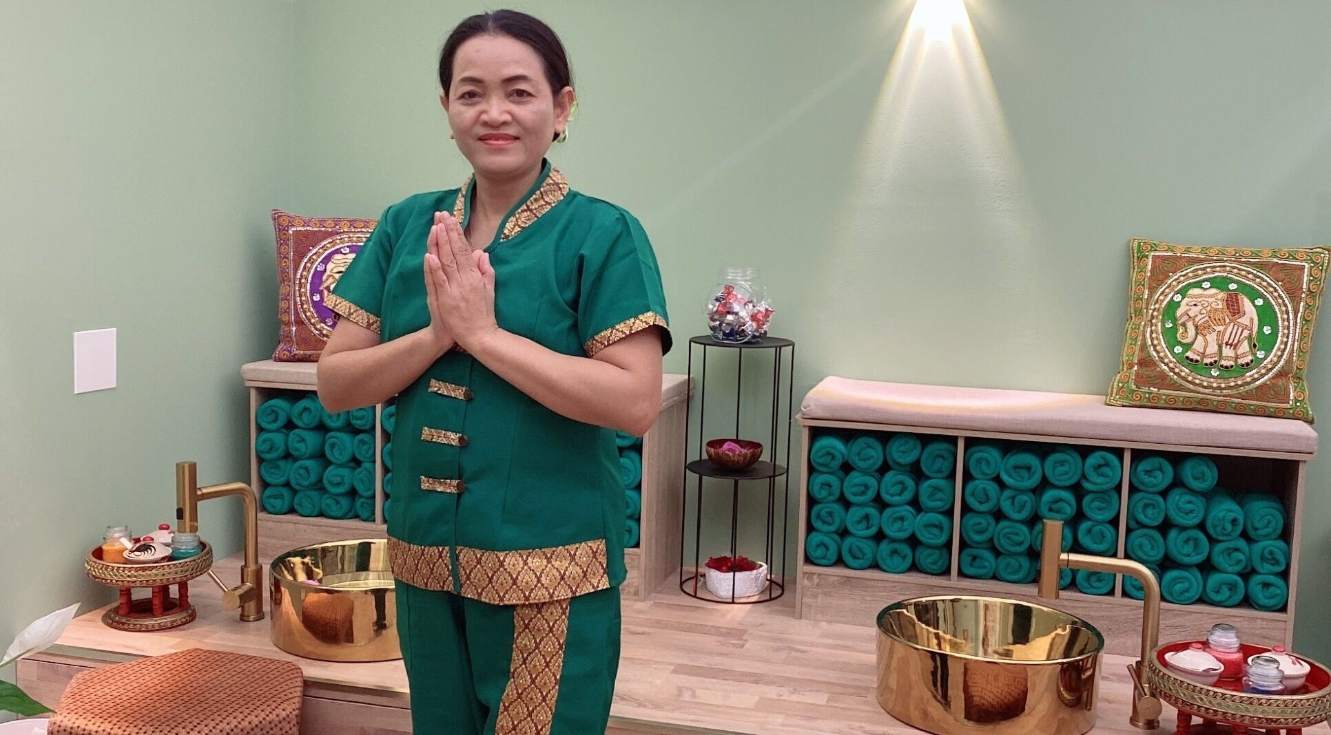 Terapeuta sorridente a Locarno Siam Massage, Locarno, Ticino, CH, in ambiente sereno con ciotola dorata.