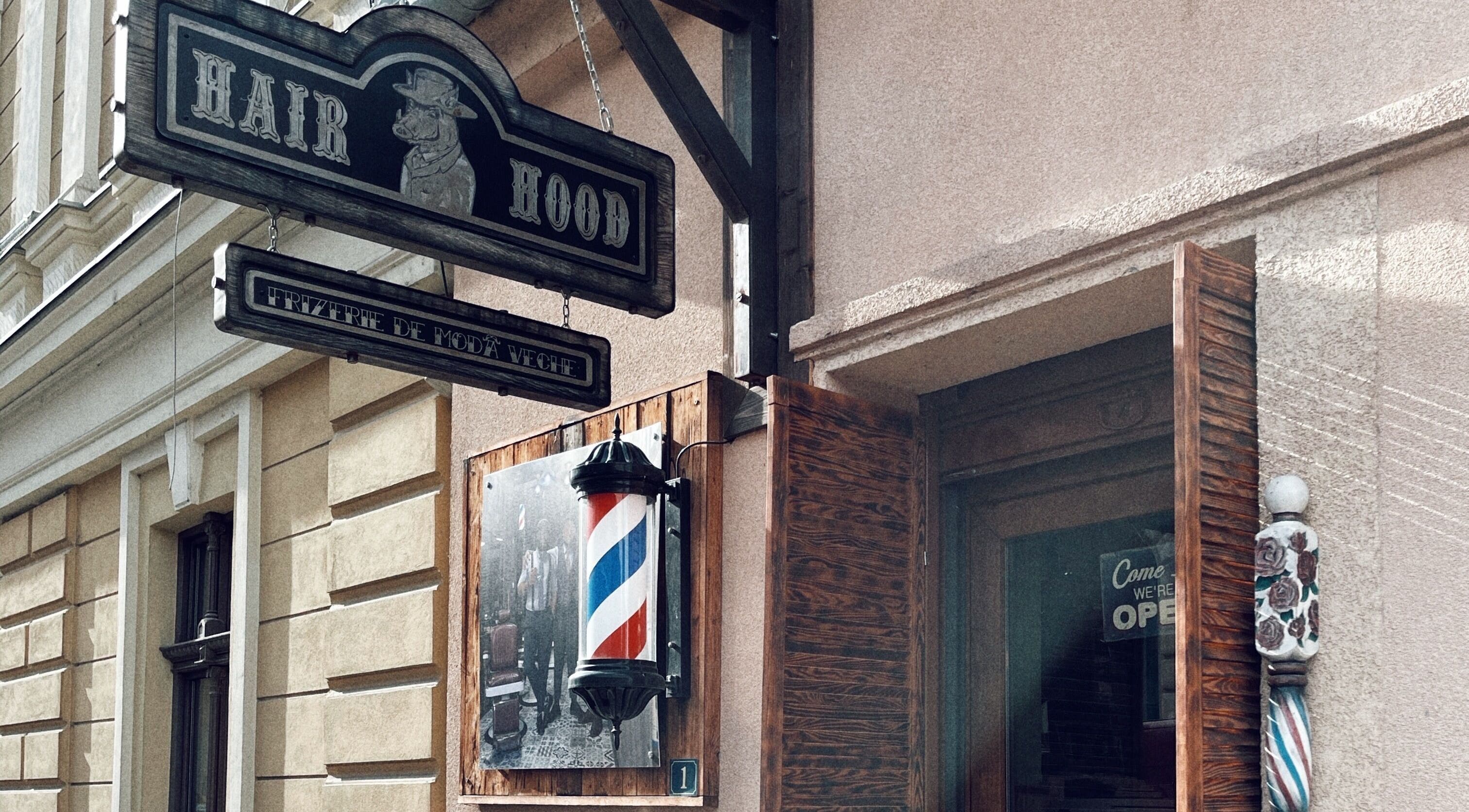Semn vintage al frizeriei Hair Hood 1, Timișoara, Județul Timiș, RO, evidențiind stilul clasic.