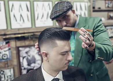 Frizer profesionist creând o tunsoare elegantă la Hair Hood 1, Timișoara, Județul Timiș, RO.