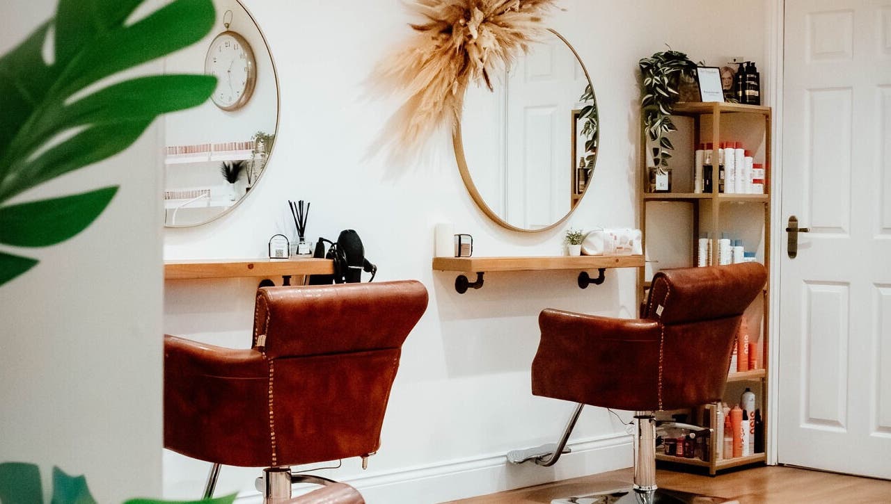Elegant salon interior at Ivy Studios in Ripley, England, GB, showcasing stylish chairs and beauty products.