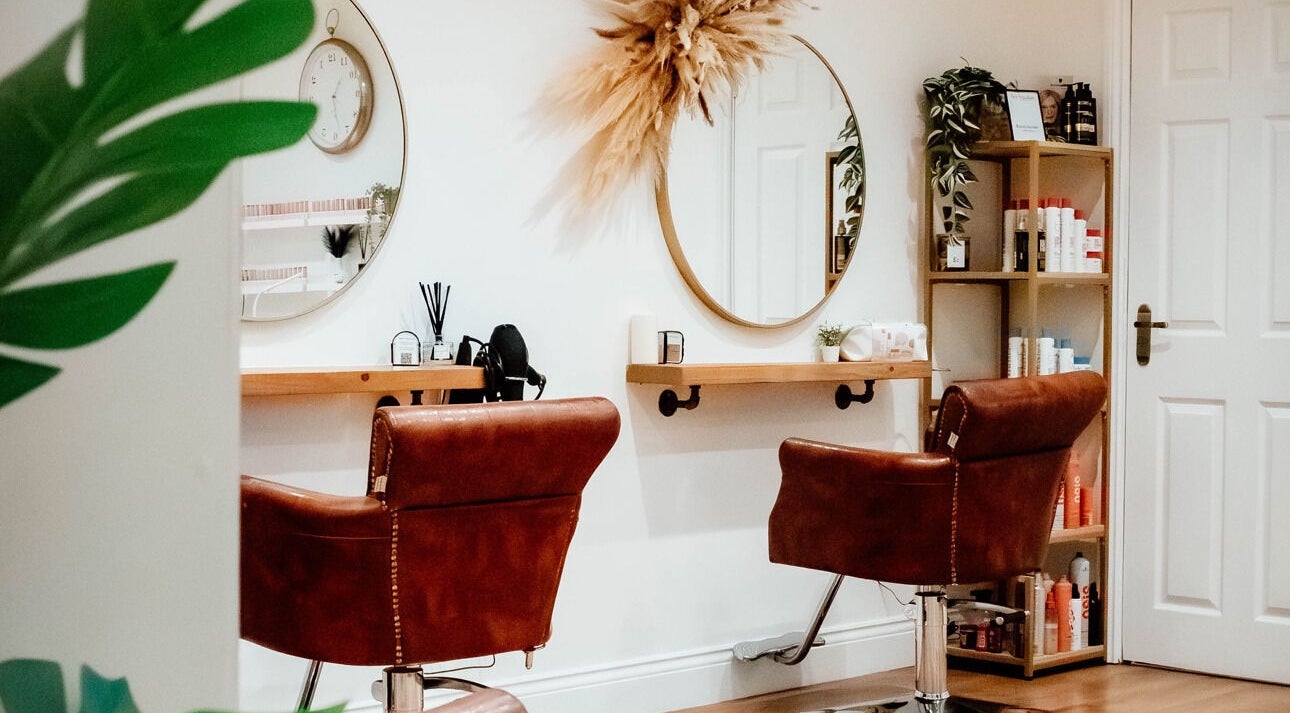 Elegant salon interior at Ivy Studios in Ripley, England, GB, showcasing stylish chairs and beauty products.
