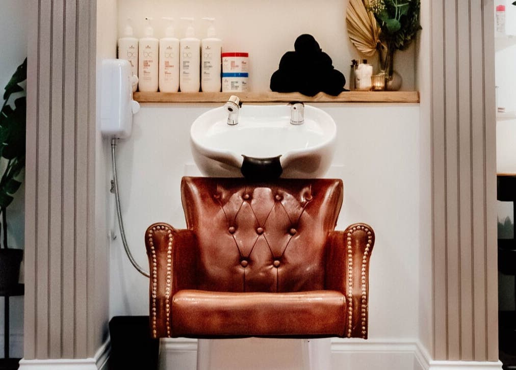 Luxurious wash station at Ivy Studios in Ripley, England, GB, featuring a leather chair and premium products.