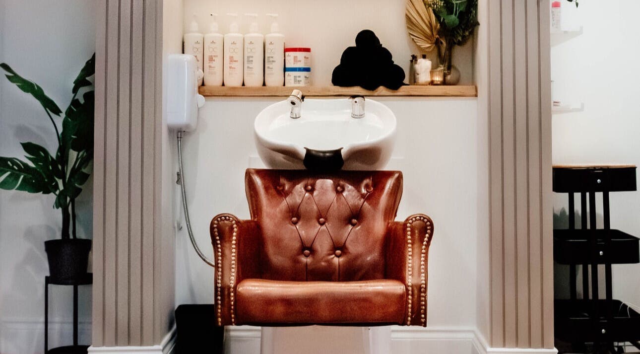 Luxurious wash station at Ivy Studios in Ripley, England, GB, featuring a leather chair and premium products.