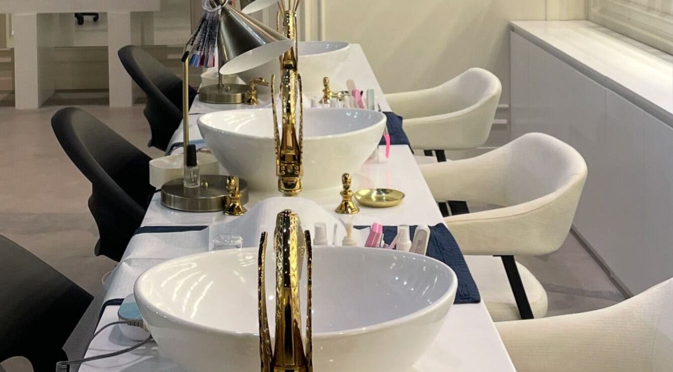 Elegant nail stations at Baran Nail Bar, Seeb, Muscat Governorate, OM, featuring plush chairs and gold accents.