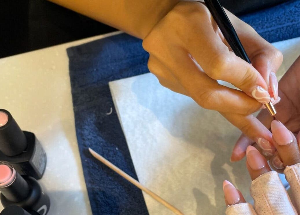 Nail artist at Baran Nail Bar in Seeb, Muscat Governorate, OM applying detailed designs.