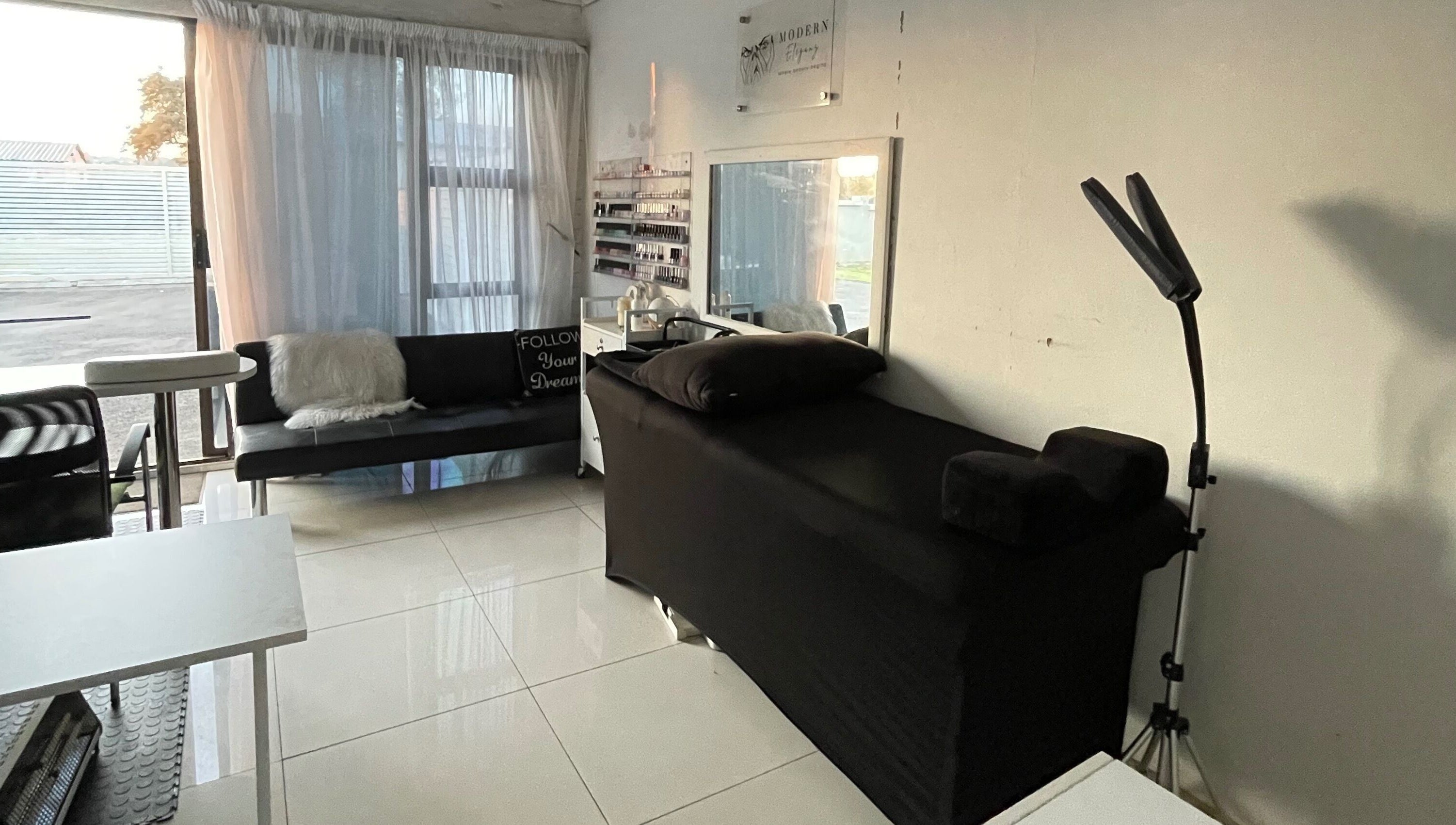 Modern Eleganz beauty room with black treatment bed and natural light, Soweto, Gauteng, ZA.