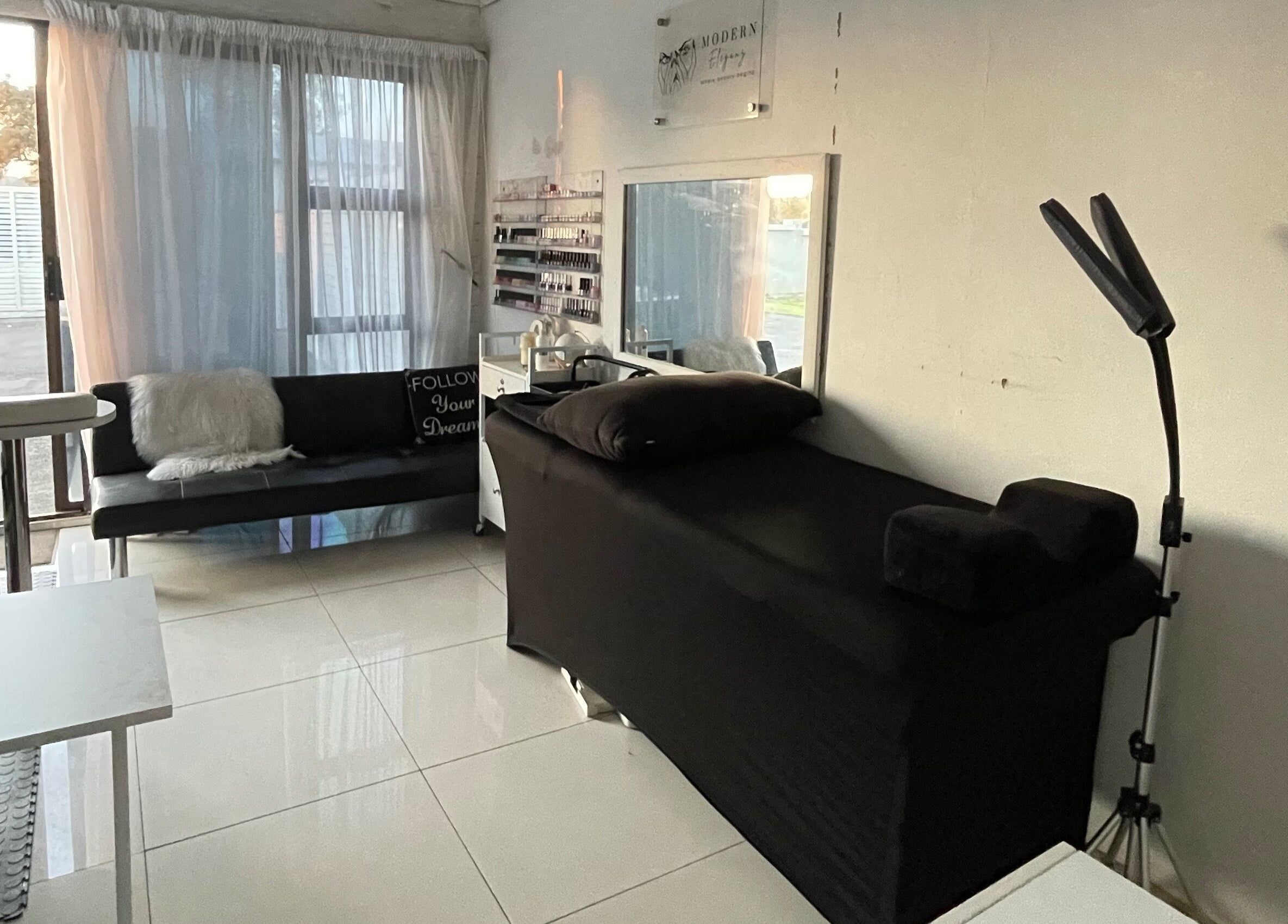 Modern Eleganz beauty room with black treatment bed and natural light, Soweto, Gauteng, ZA.
