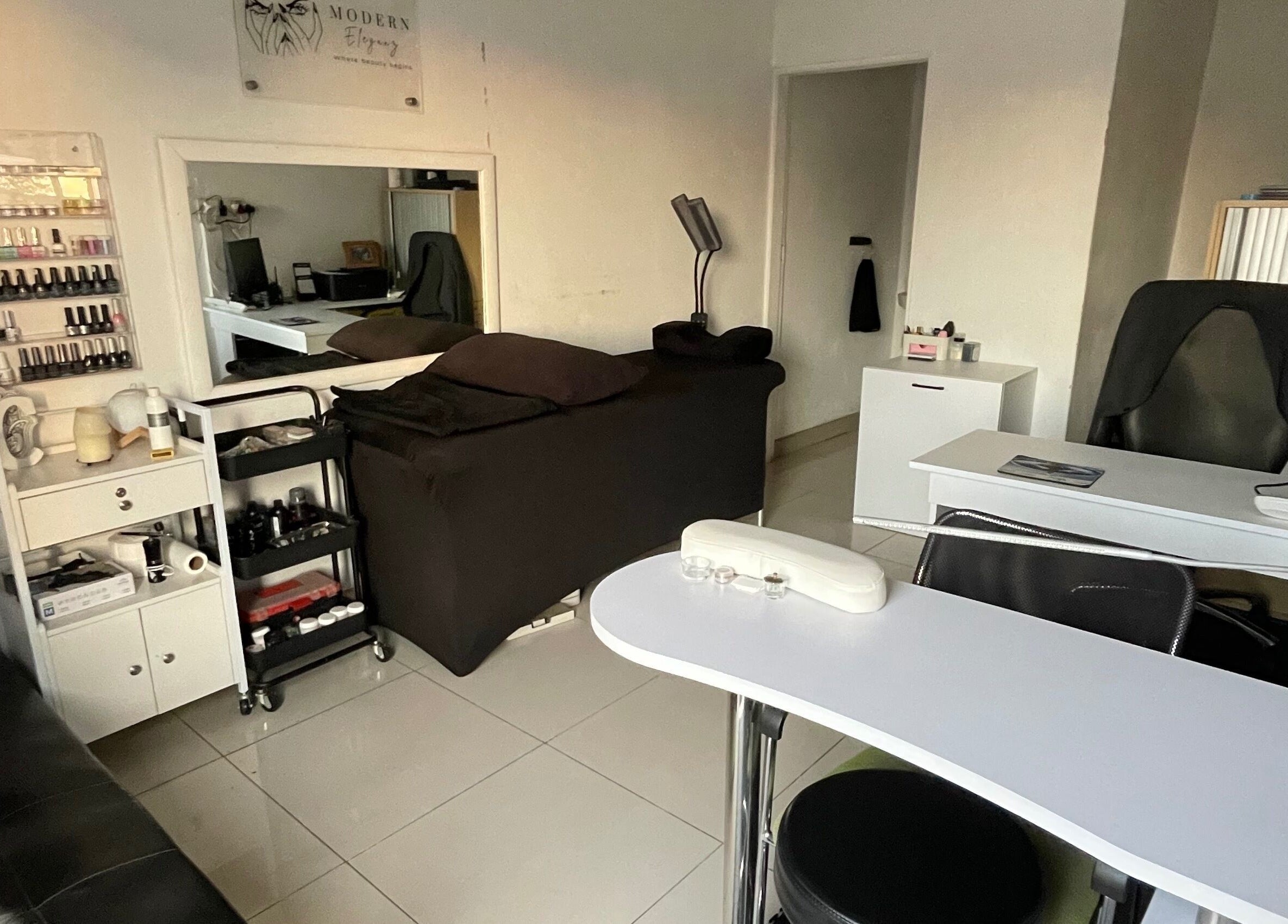 Elegant nail salon interior at Modern Eleganz, Soweto, Gauteng, ZA with sleek furnishings and polish display.