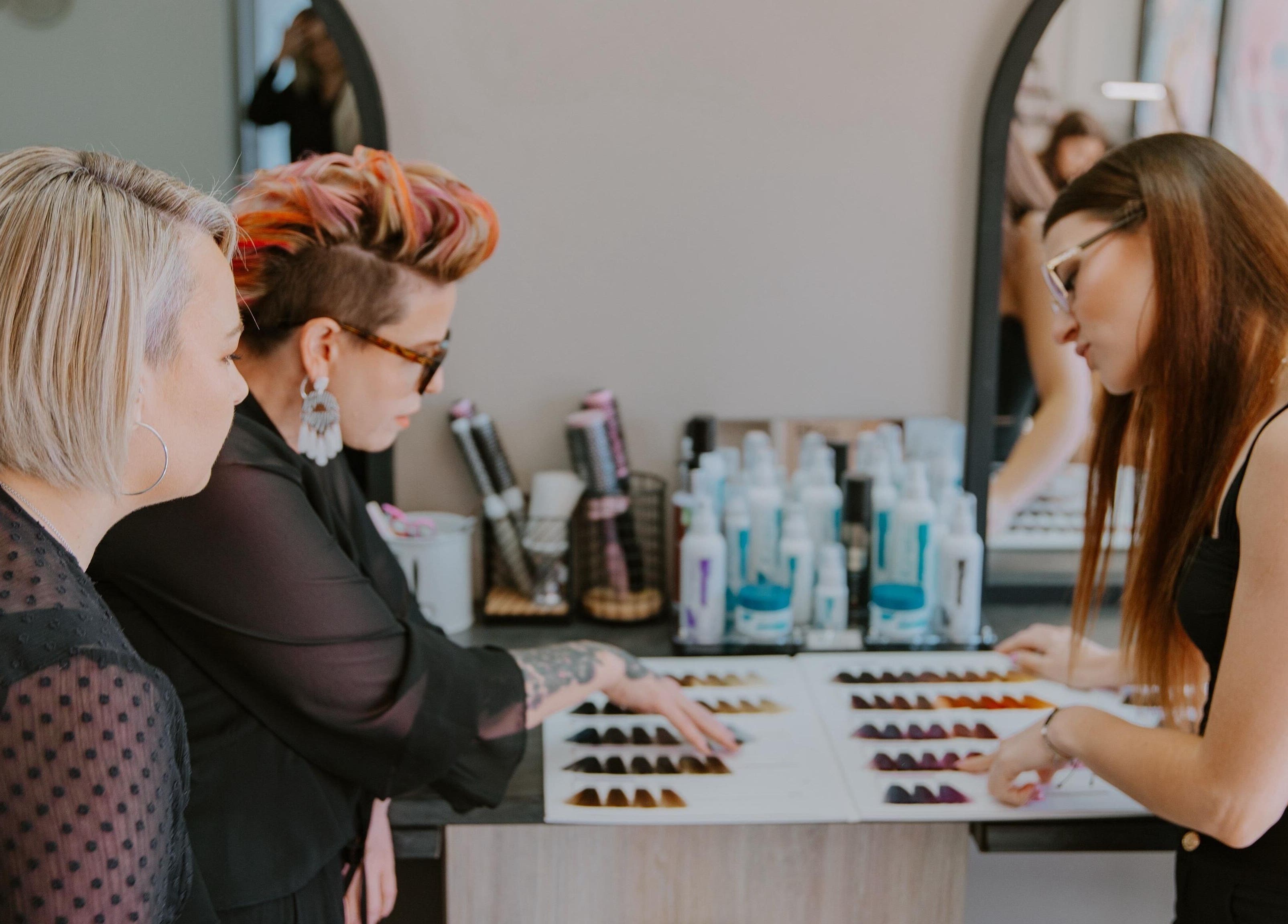 Stylists discussing hair color options at Mooi Salon, Bloemfontein, Free State, ZA.