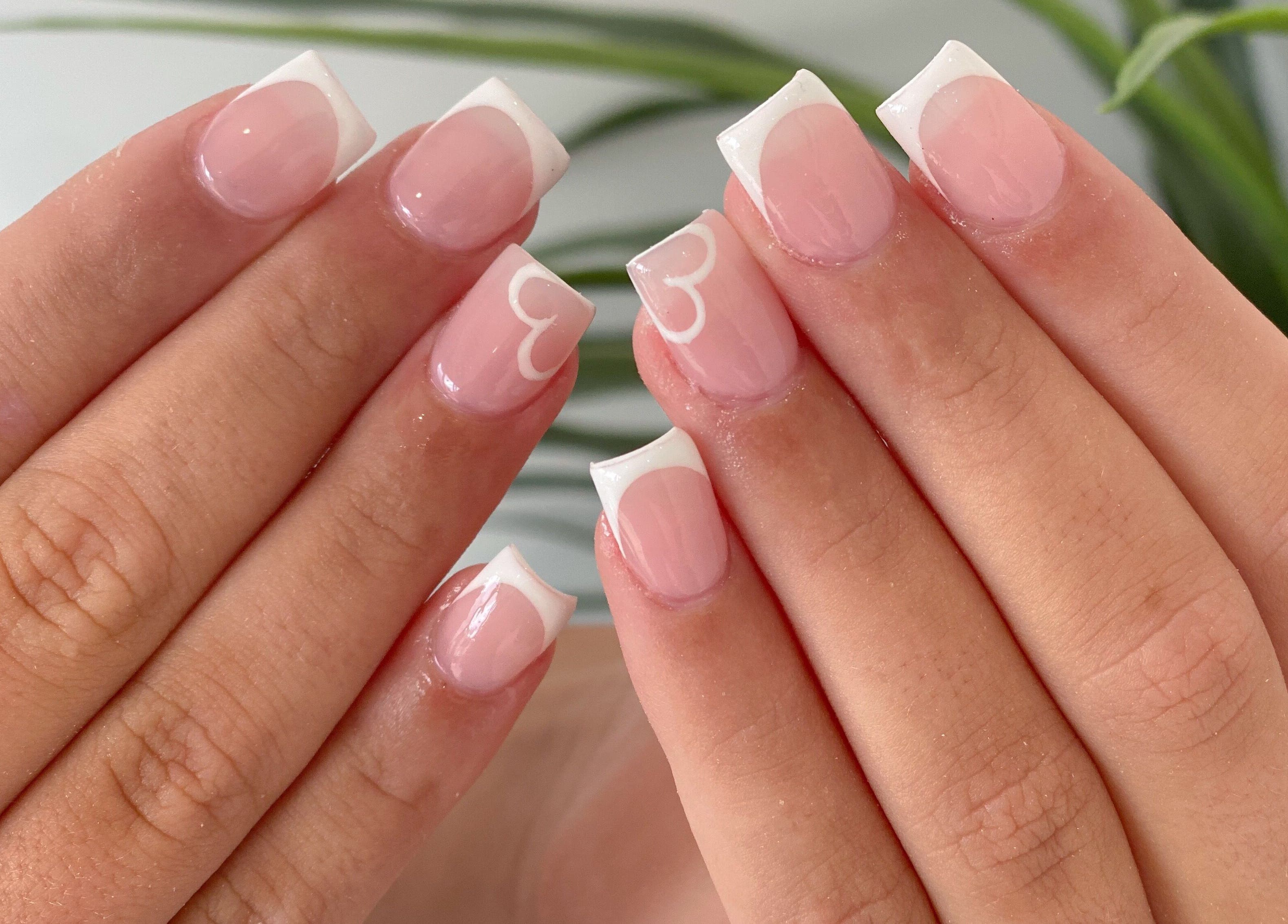 Elegant French manicure with heart design at Jelly Nails, London, England, GB.