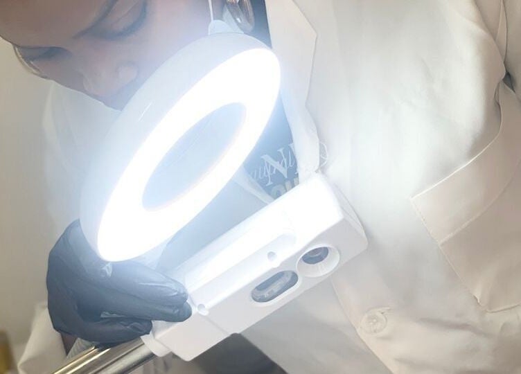 Esthéticienne examinant un visage sous une lampe à Natural Deific - Douala, Douala, Région Du Littoral, CM.