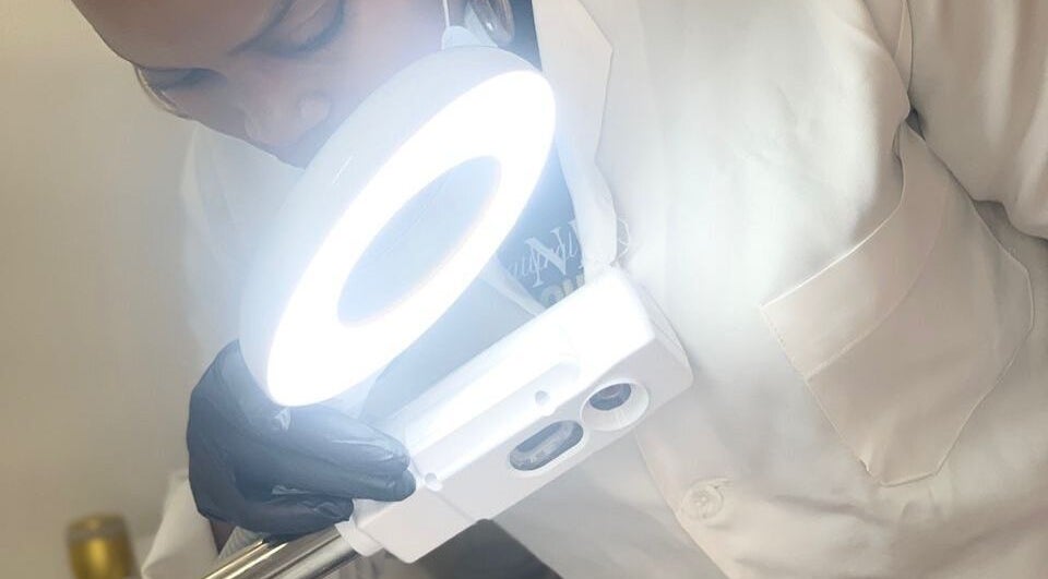 Esthéticienne examinant un visage sous une lampe à Natural Deific - Douala, Douala, Région Du Littoral, CM.