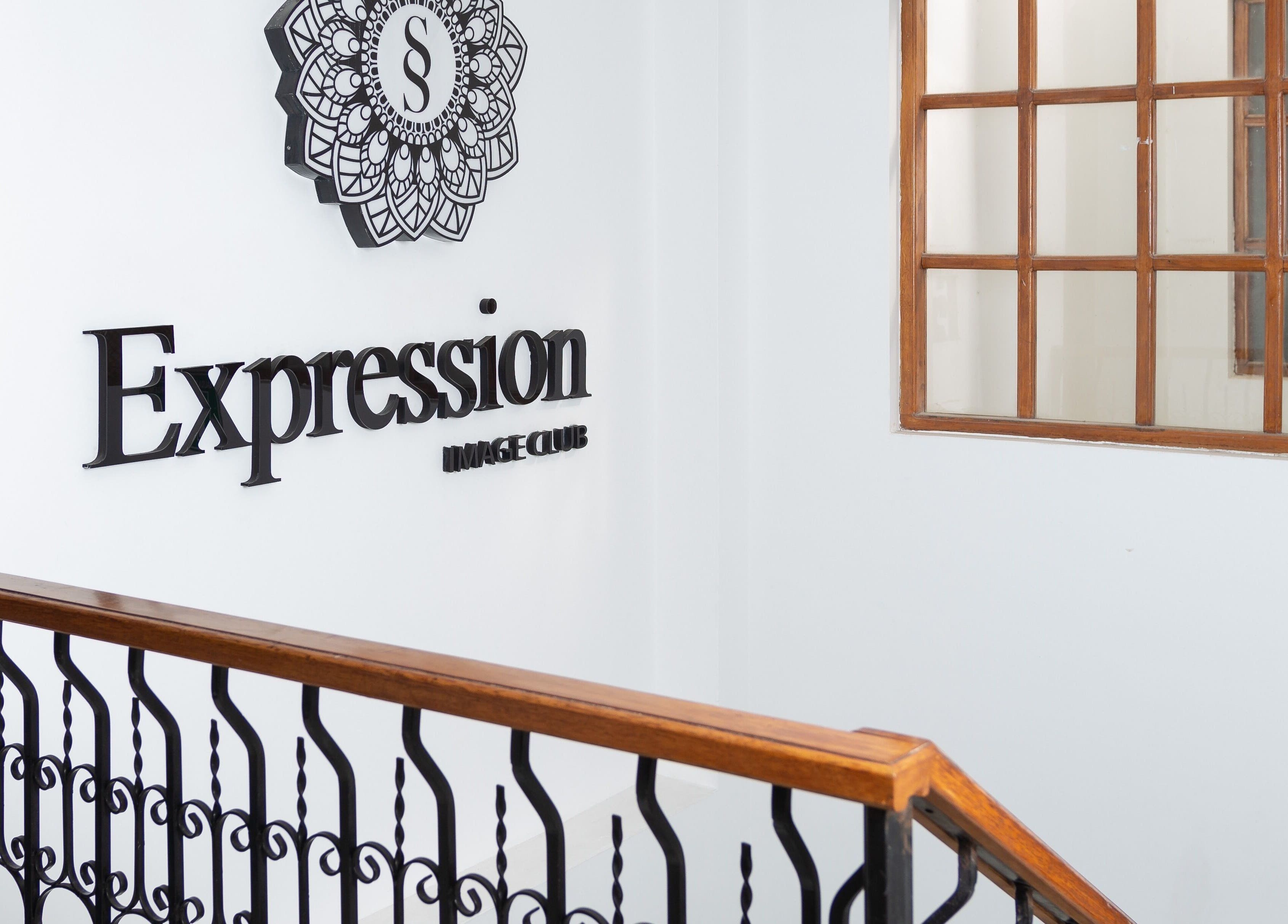 Entrada de Expression Image Club en Puembo, Pichincha, EC con diseño de baranda y logo sofisticado.