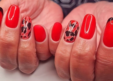 Bright red nails with artistic designs at Magical Nails by Ewa, Spalding, England, GB.