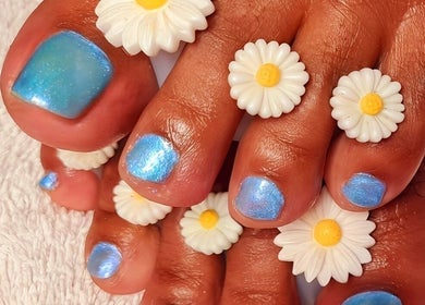 Bright blue toenails adorned with daisy flowers at Magical Nails by Ewa, Spalding, England, GB.