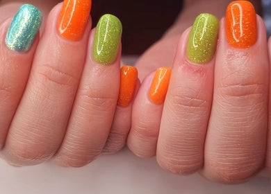 Vibrant multicolored nail art at Magical Nails by Ewa in Spalding, England, GB showcasing green, orange, and blue hues.