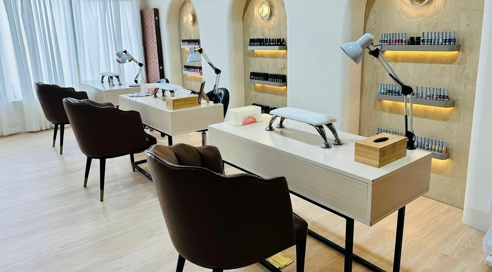 Chic nail care setup at Anotha Beauty Salon in Dubai, AE featuring sleek leather chairs and polished workstations.