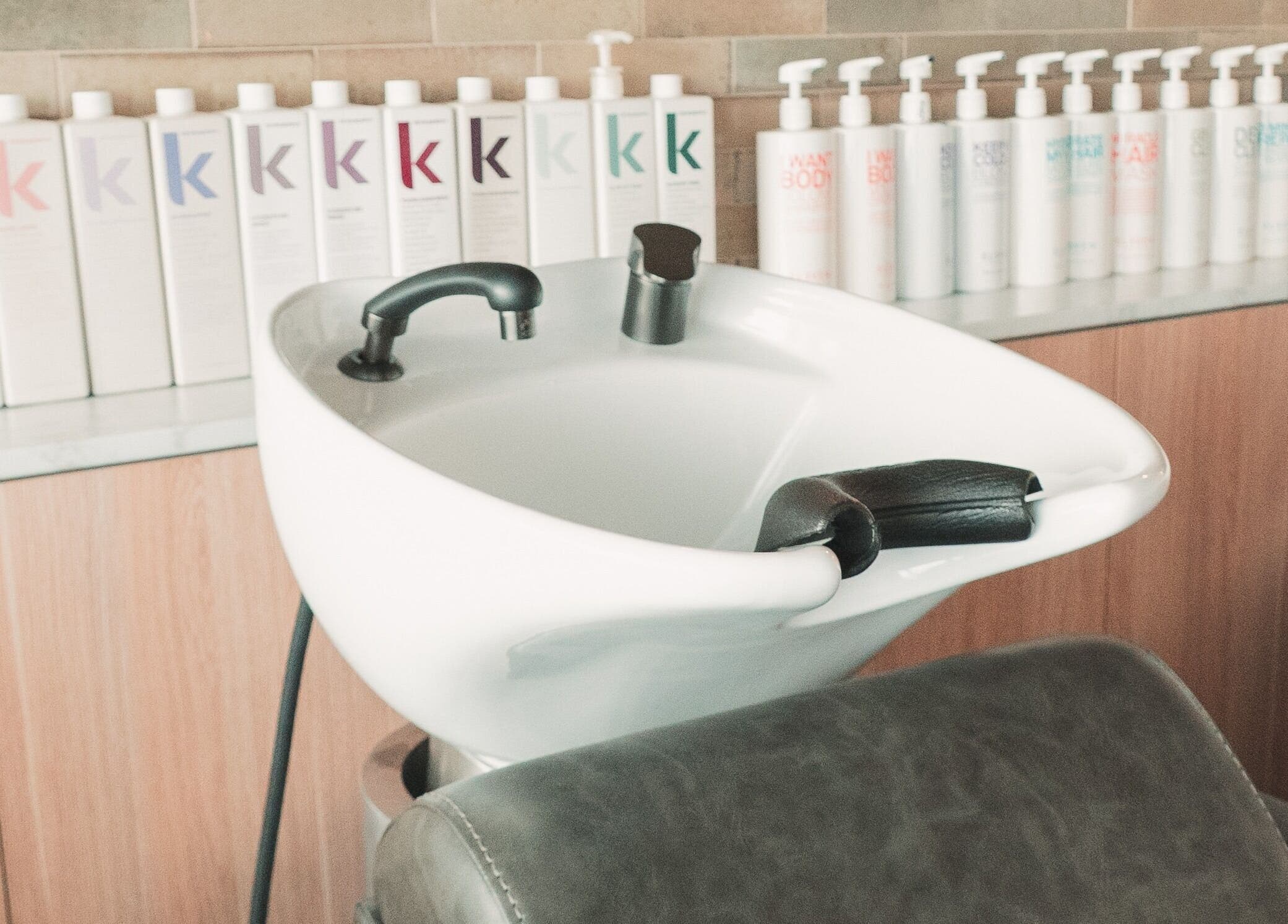 Modern wash station at The Blowout Bar - Brighton, located in Brighton, Victoria, AU, with hair care products.