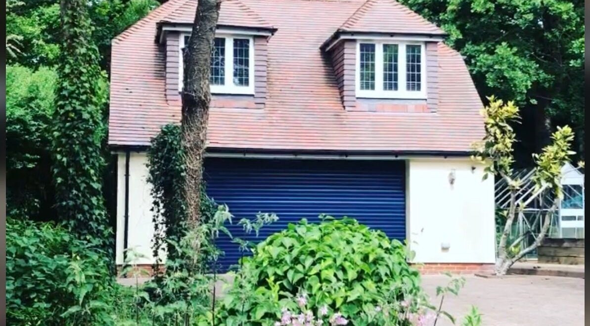 Front view of Worthing Clinic with Nurse Rebecca in Worthing, England, surrounded by lush greenery.