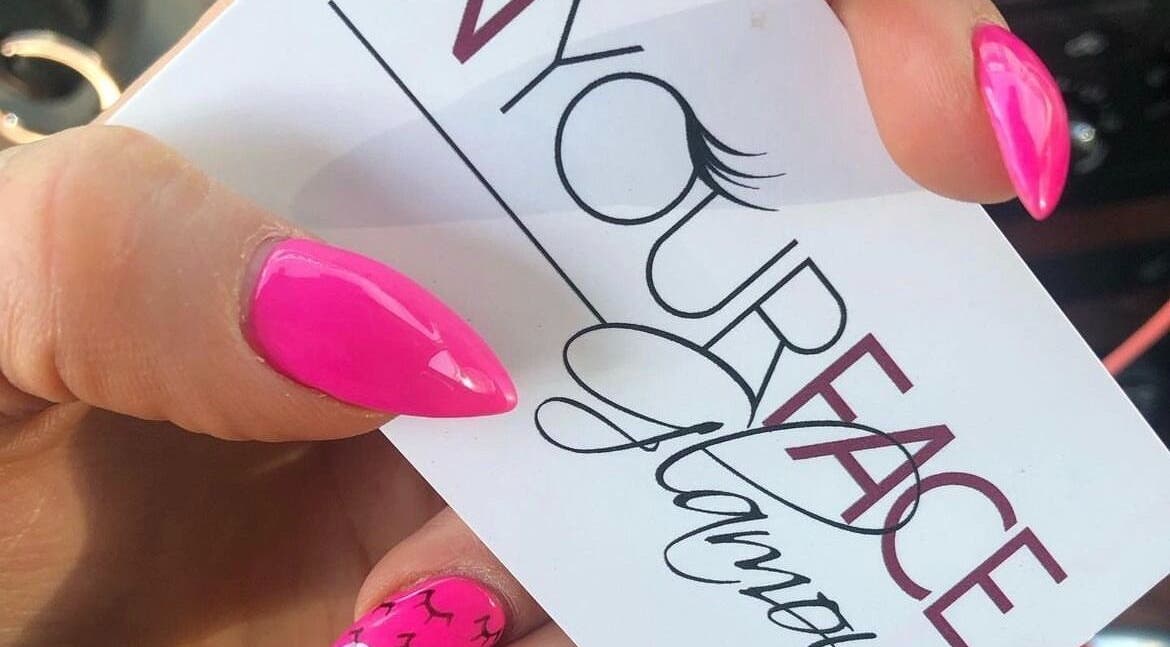 A vibrant pink manicure holding In Your Face Glamour card in Edmonton, Alberta, CA.