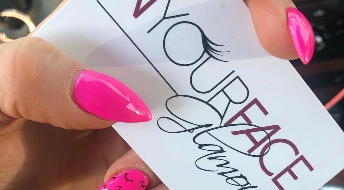 A vibrant pink manicure holding In Your Face Glamour card in Edmonton, Alberta, CA.