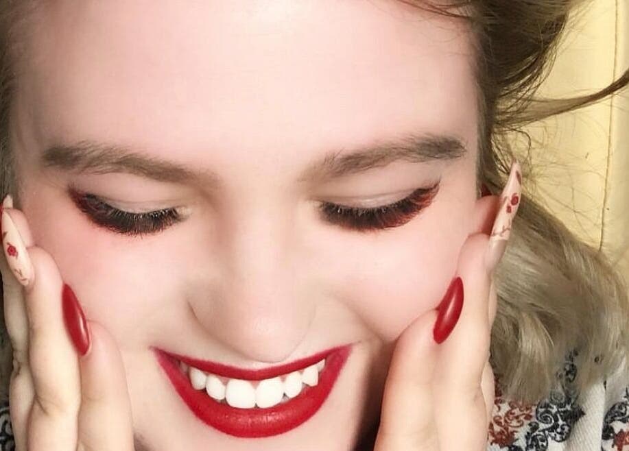 Woman with bright red lipstick smiling at In Your Face Glamour, Edmonton, Alberta, CA.