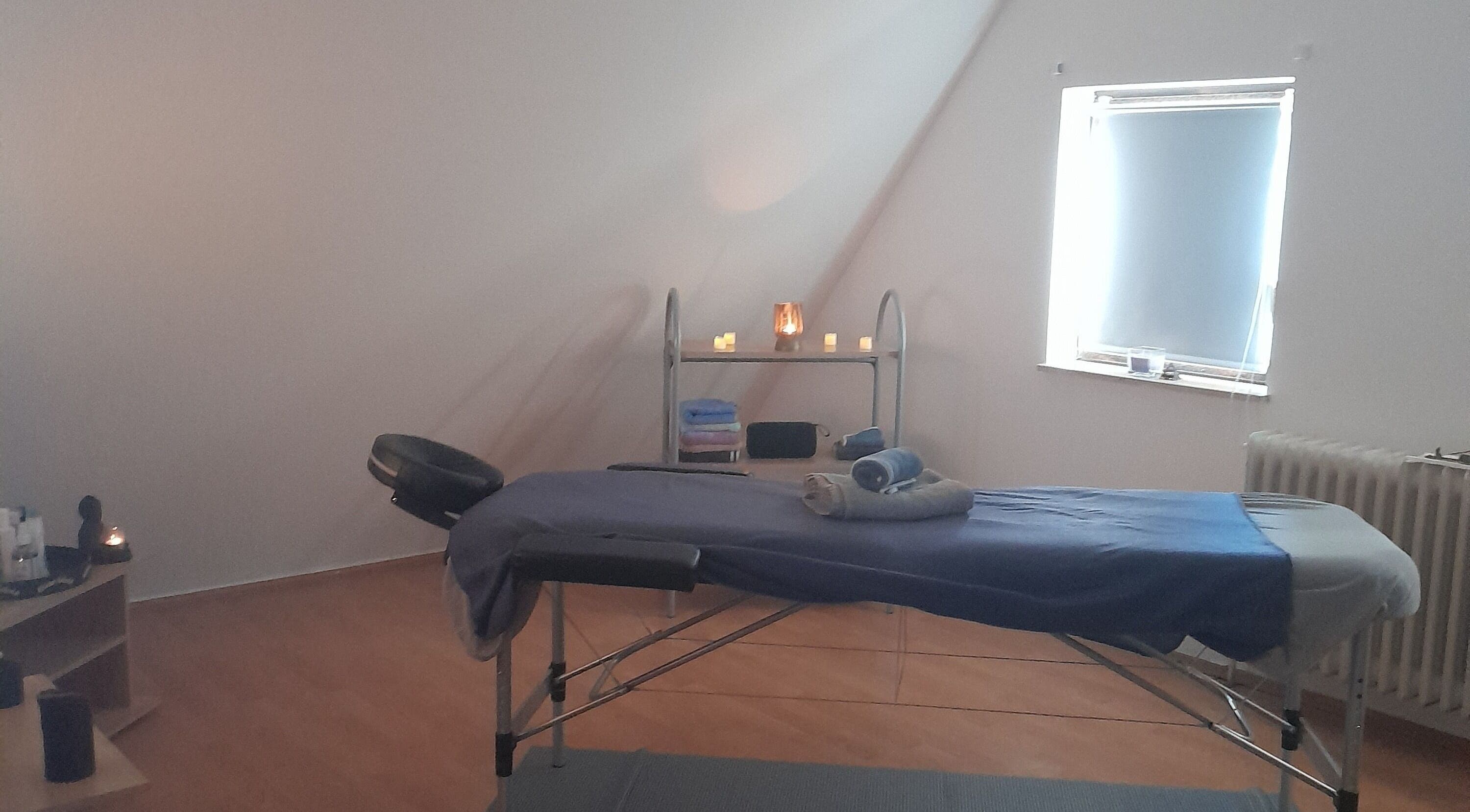 Massagezimmer bei Tommys-Massage-Zirndorf in Zirndorf, Bayern, DE mit entspannender Atmosphäre und Kerzenlicht.