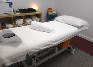 Cozy treatment room at Metta Therapies, Adelaide, South Australia, AU, featuring a massage table and warm lighting.