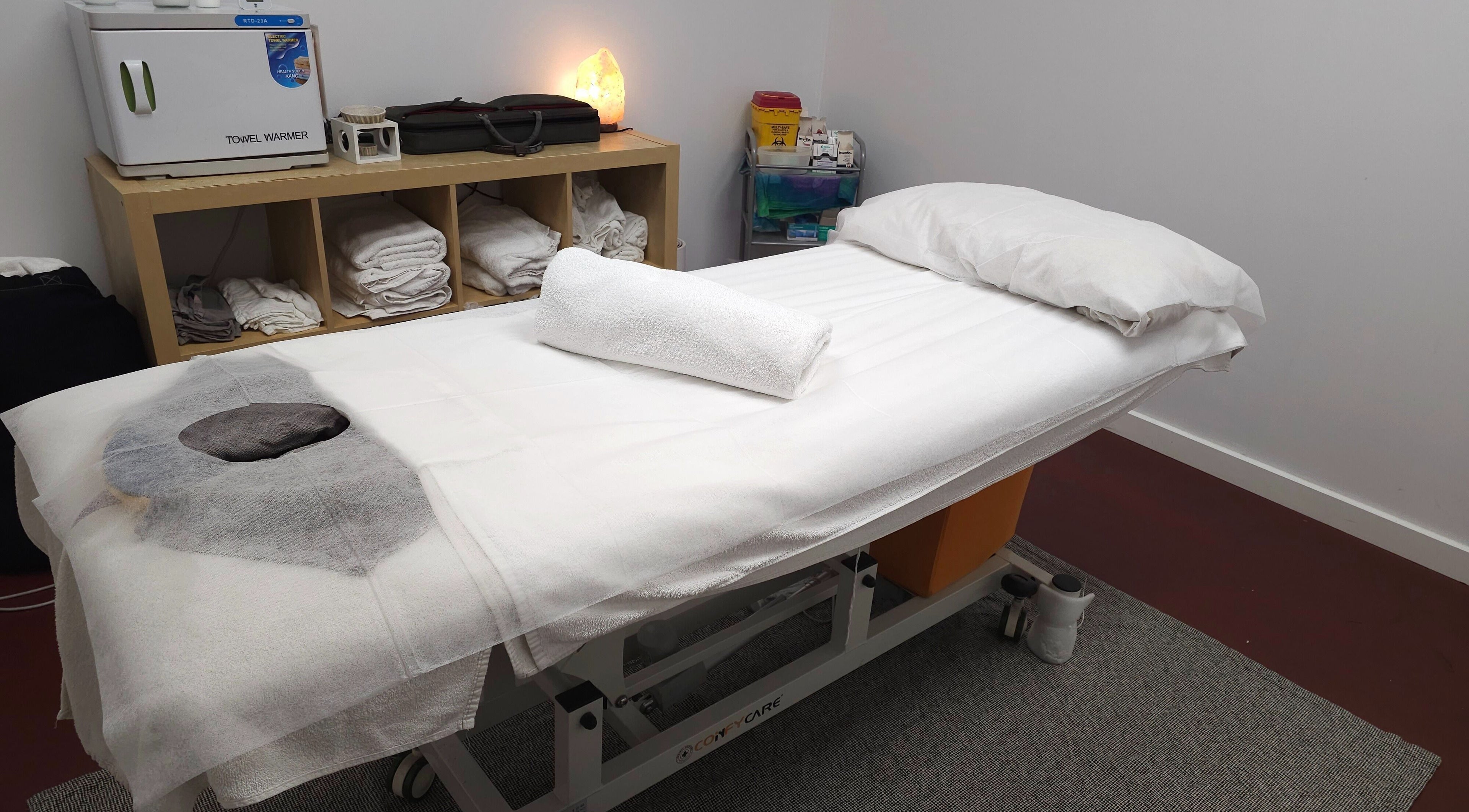 Cozy treatment room at Metta Therapies, Adelaide, South Australia, AU, featuring a massage table and warm lighting.