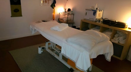 Relaxing massage room at Metta Therapies, Adelaide, South Australia, AU with warm lighting and cozy linens.