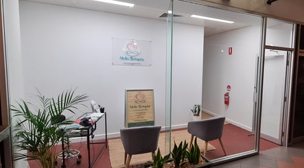 Entrance of Metta Therapies in Adelaide, South Australia, AU with a cozy sitting area and lush plants.