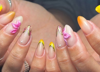 Intricate floral nail art at Oh Nails by Lauren in Livingston, Scotland, GB. Yellow and pink designs on elegant fingers.