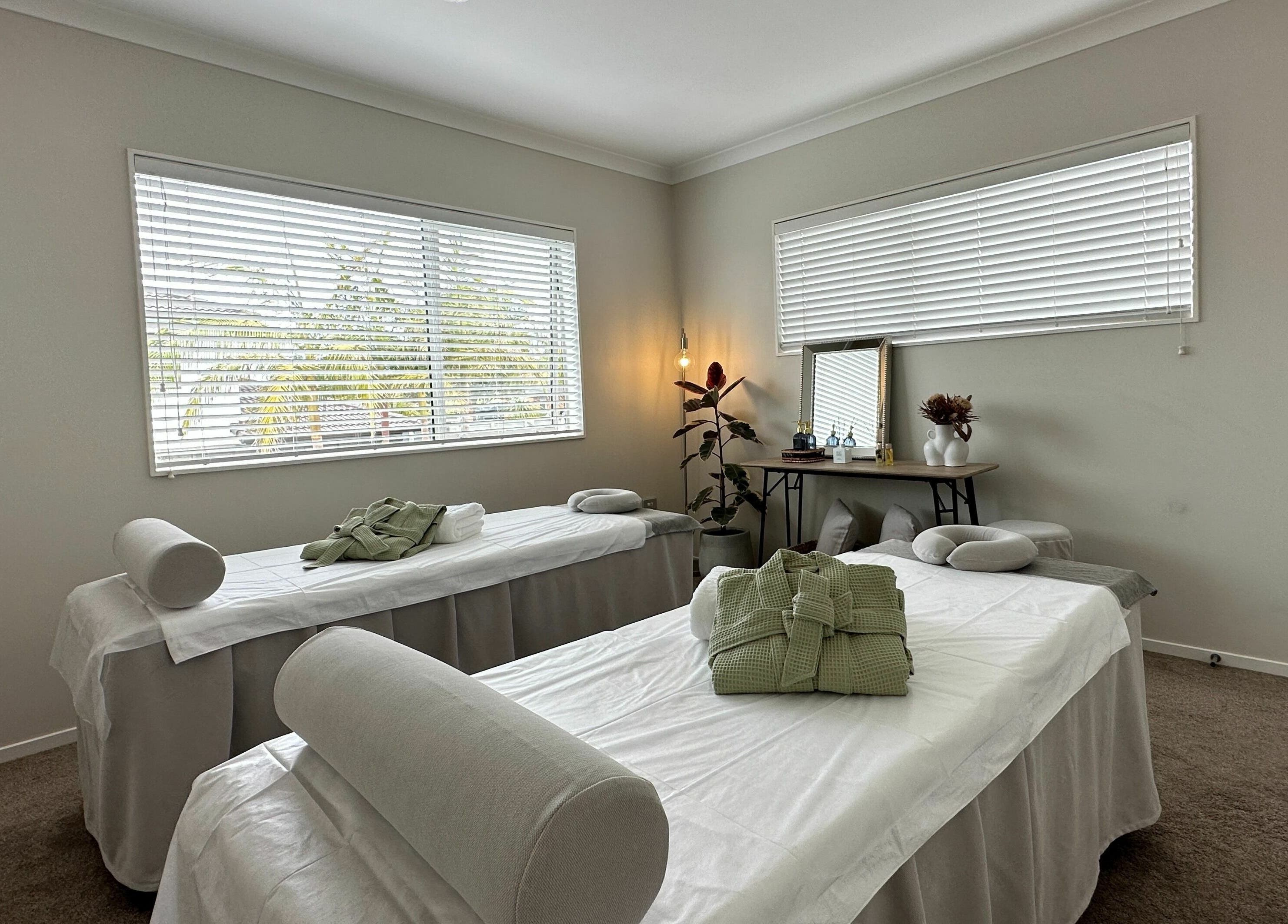 Tranquil massage room at Wellness Massage Silverdale in Silverdale, Auckland, NZ with two prepared beds.