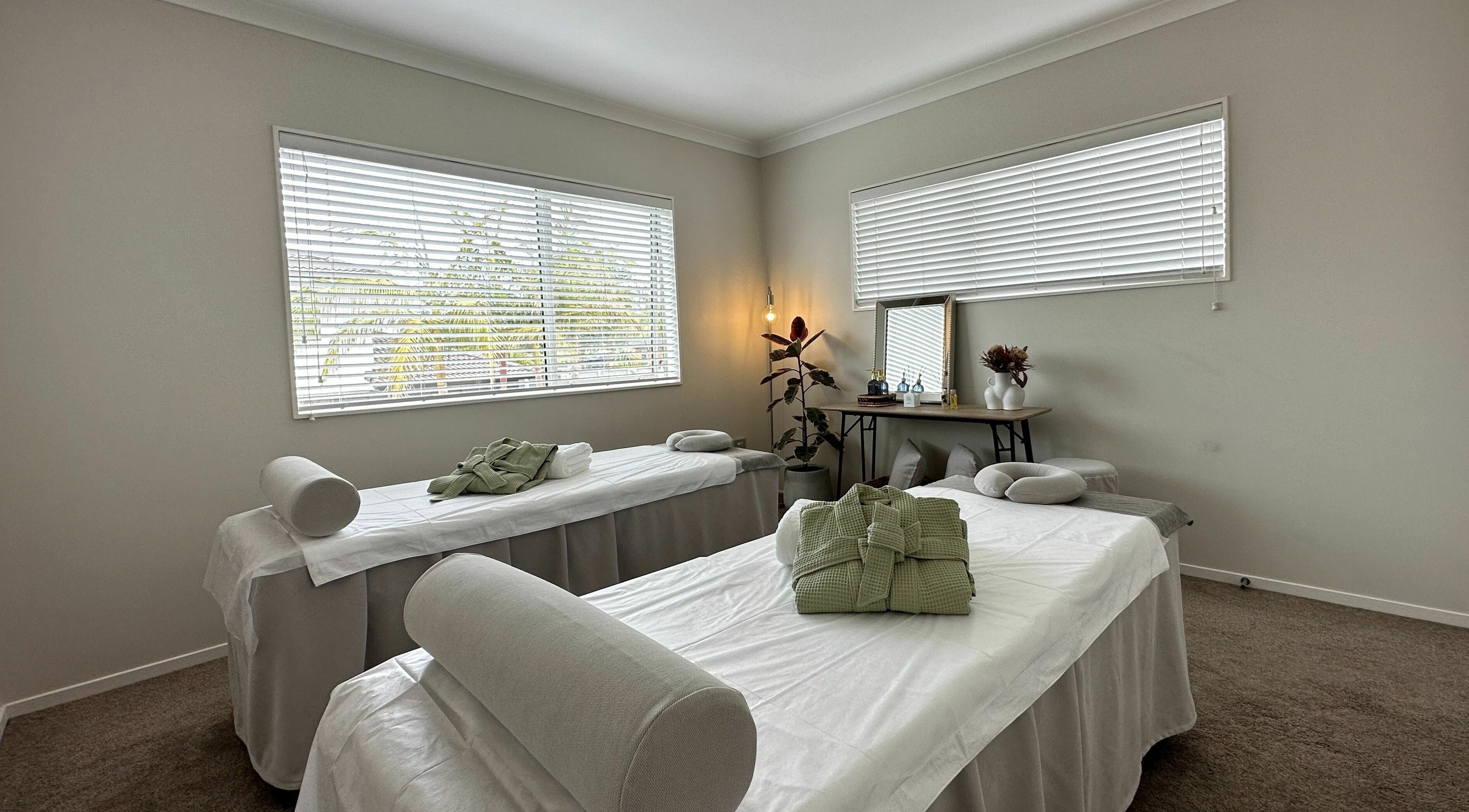 Tranquil massage room at Wellness Massage Silverdale in Silverdale, Auckland, NZ with two prepared beds.