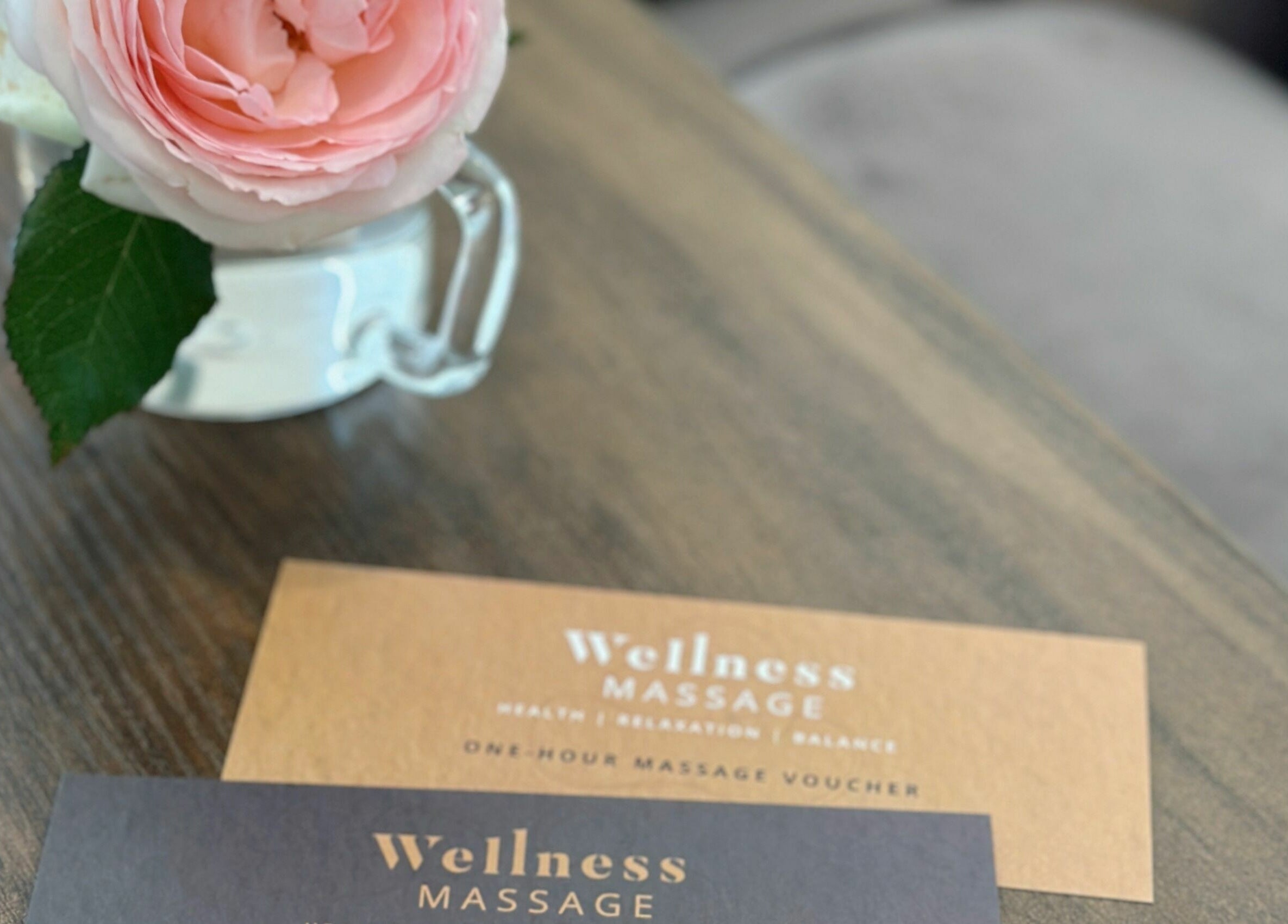 Wellness Massage Silverdale vouchers with pink rose on table, Silverdale, Auckland, NZ.