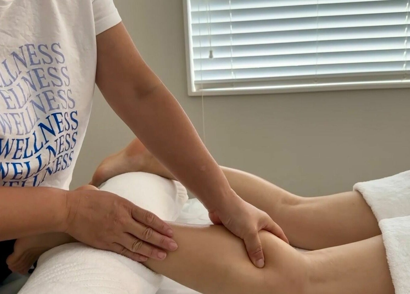 Therapist provides leg massage at Wellness Massage Silverdale, Silverdale, Auckland, NZ for ultimate relaxation.
