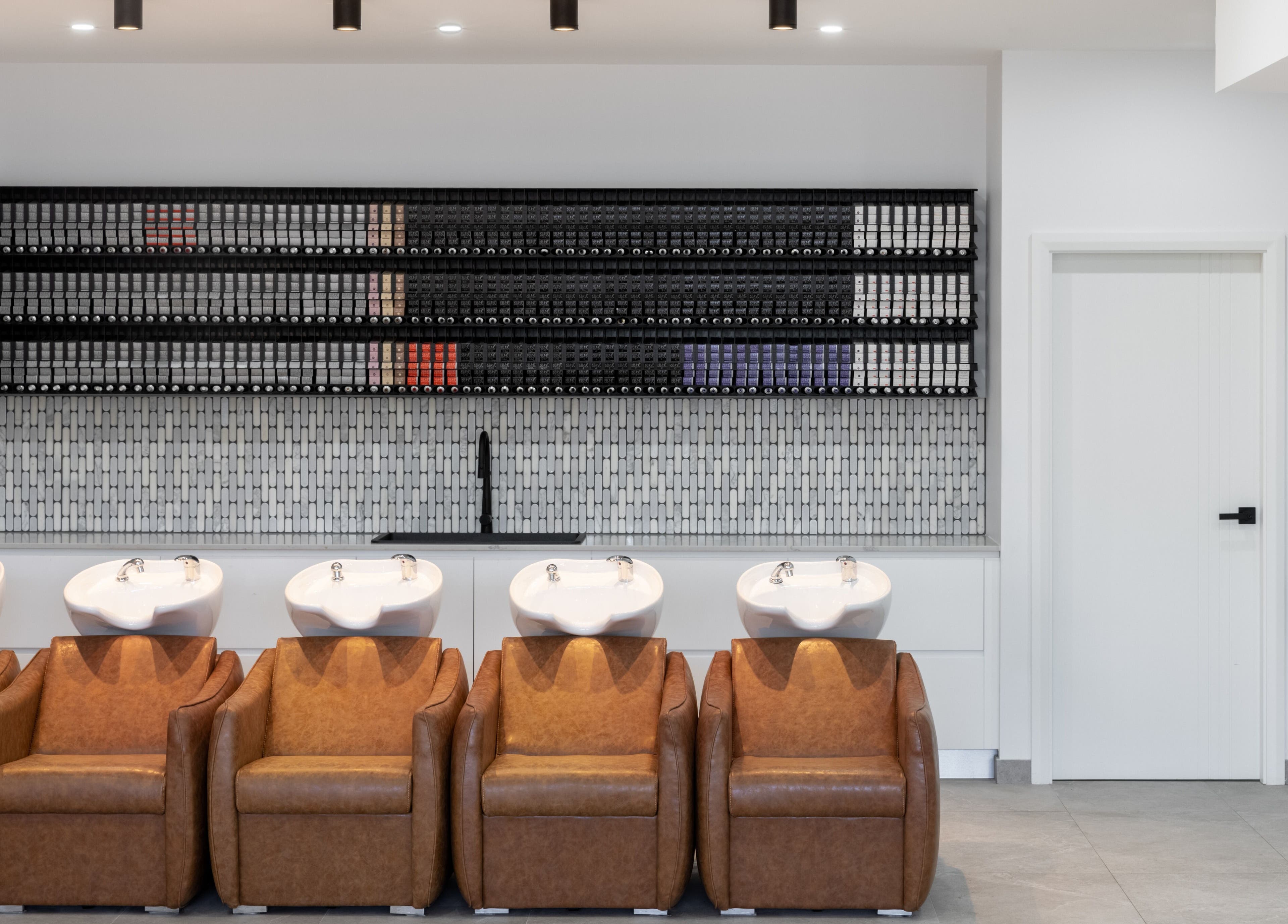 Elegant wash stations at Mane Painters, Kingsgrove, NSW, AU with leather chairs and tile accents.