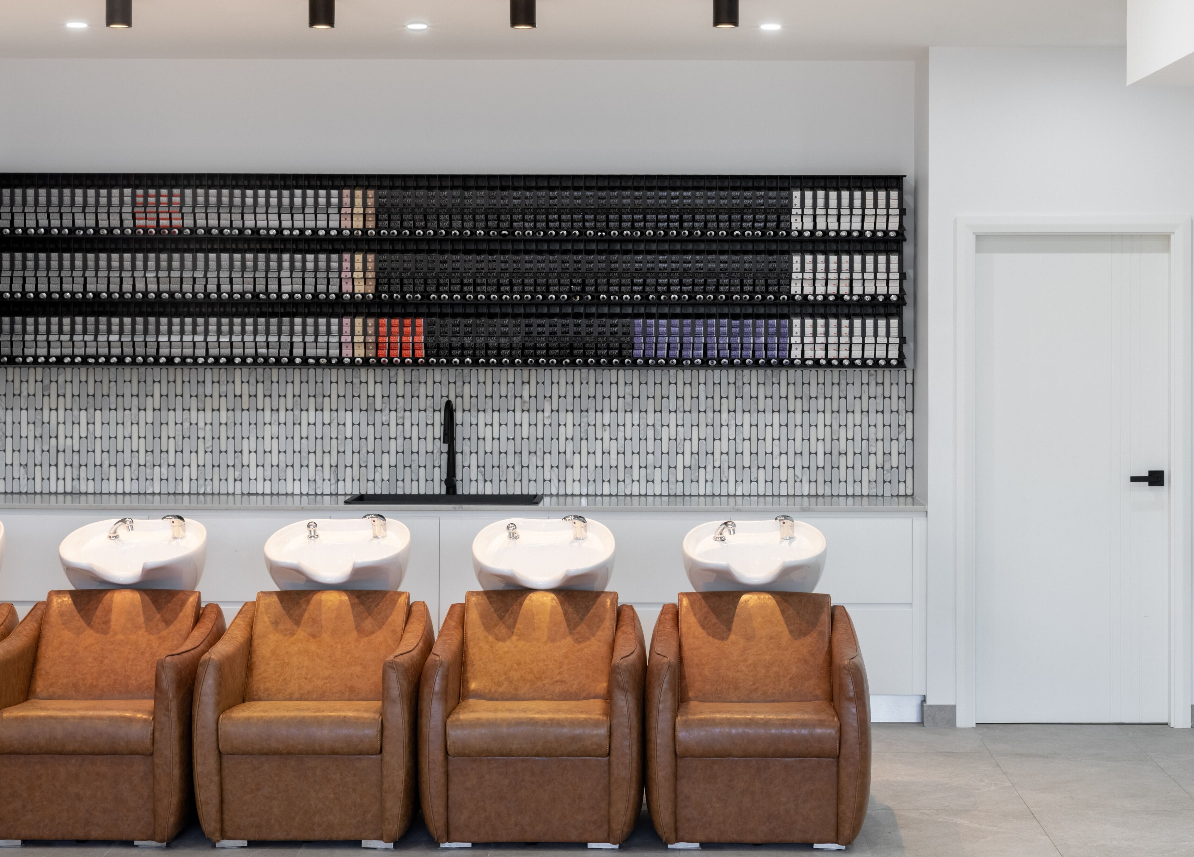 Elegant wash stations at Mane Painters, Kingsgrove, NSW, AU with leather chairs and tile accents.