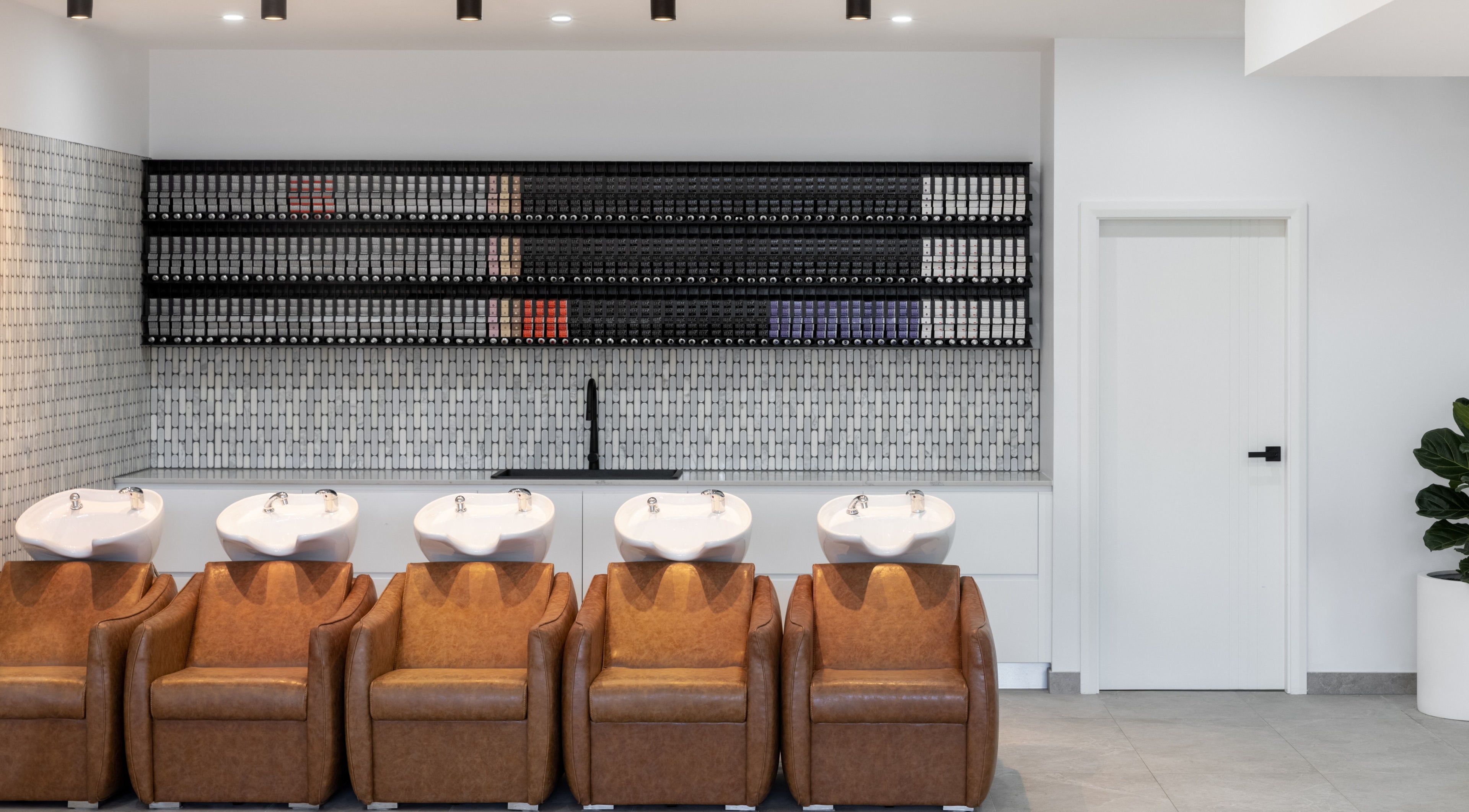 Elegant wash stations at Mane Painters, Kingsgrove, NSW, AU with leather chairs and tile accents.