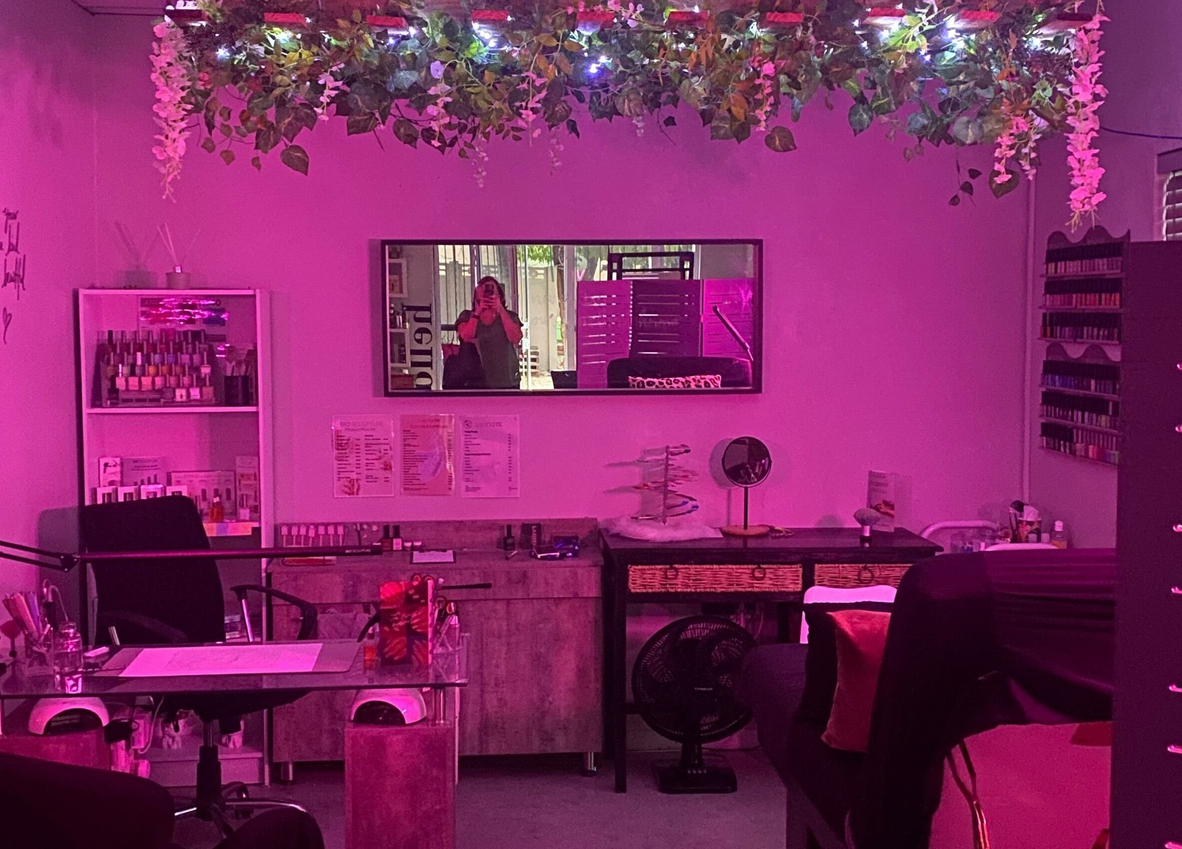 Charming interior of Xquisite Nails in Bloemfontein, Free State, ZA, featuring vibrant pink lighting and decor.