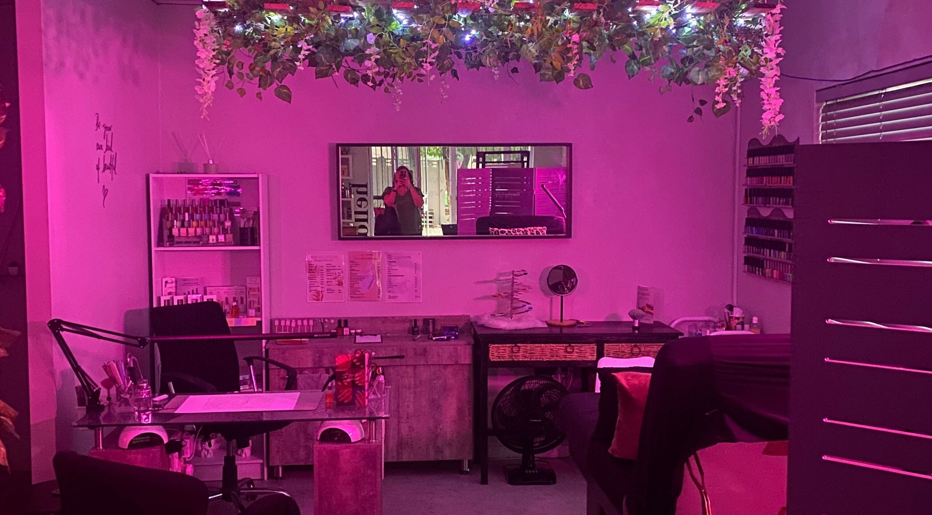 Charming interior of Xquisite Nails in Bloemfontein, Free State, ZA, featuring vibrant pink lighting and decor.