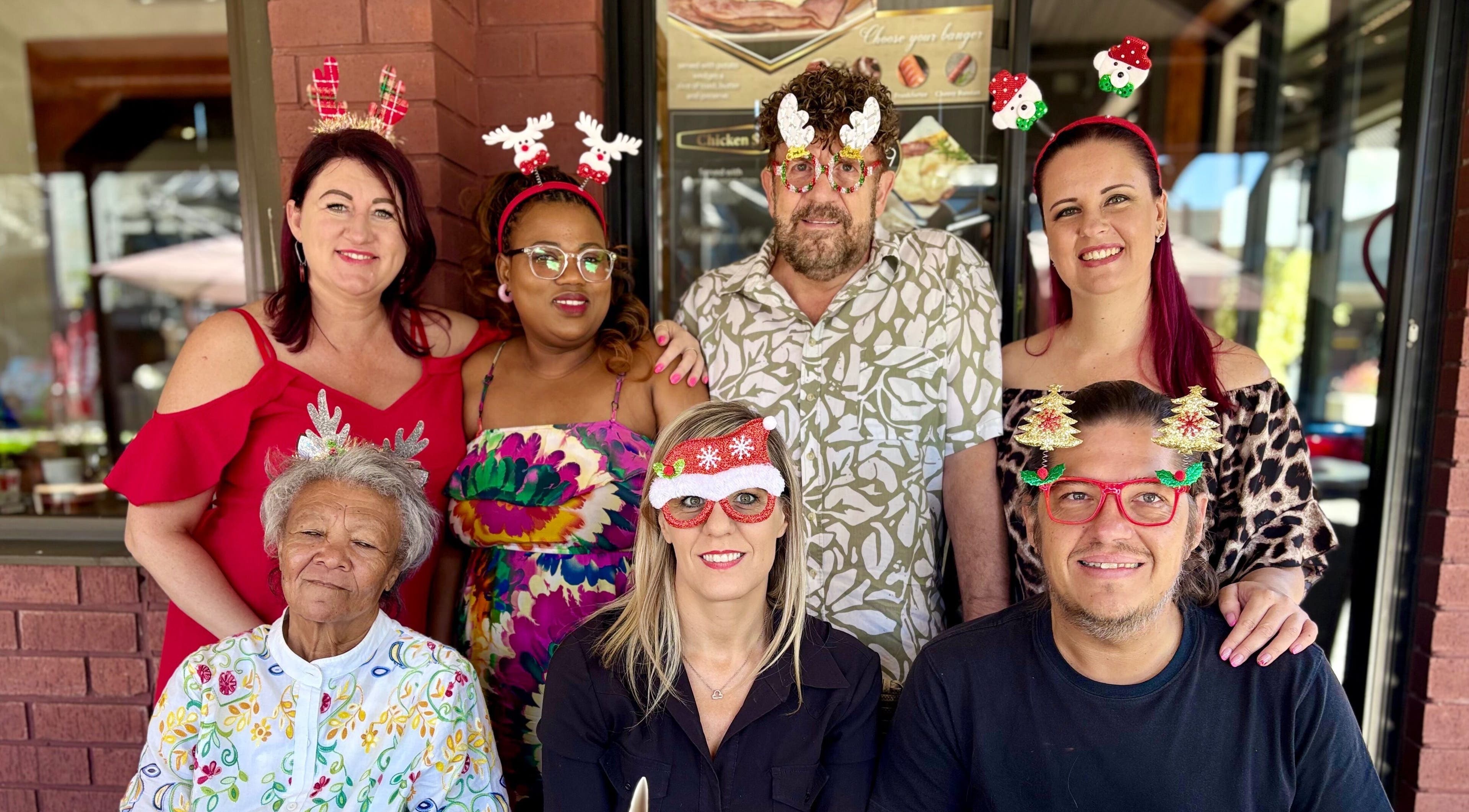 A cheerful group celebrating at Xquisite Nails, Bloemfontein, Free State, ZA, wearing colorful festive headbands.
