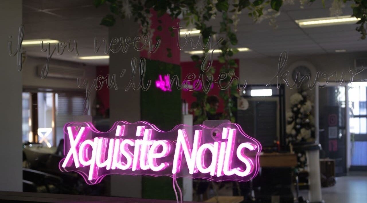 Vibrant neon sign reading 'Xquisite Nails' inside the Bloemfontein salon in Free State, ZA.